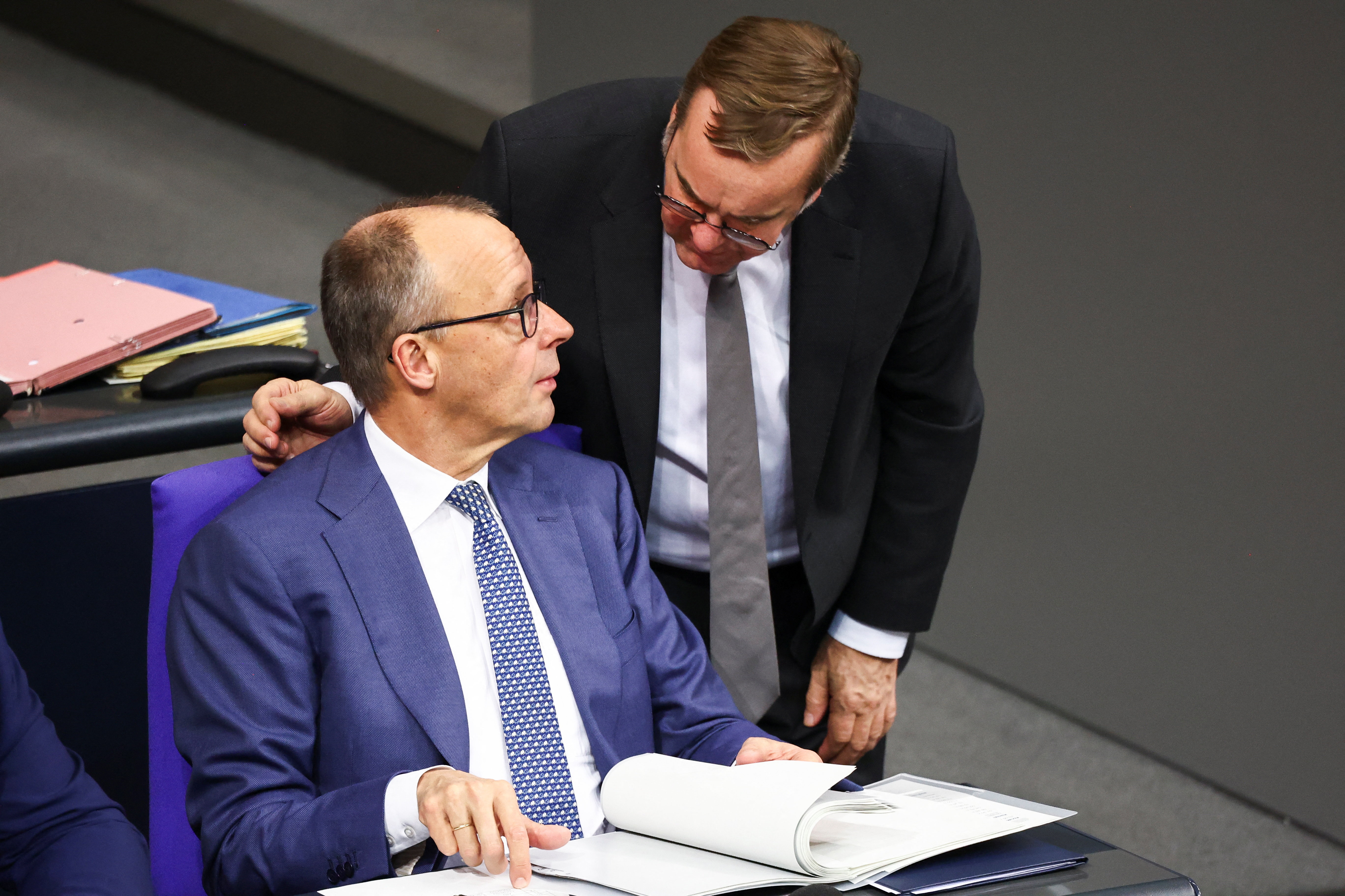 German Defence Minister Boris Pistorius talks with Chancellor Friedrich Merz at the lower house of parliament, the Bundestag, following the December 15 meeting between Ukraine's President Volodymyr Zelenskiy, European leaders, and EU, NATO and U.S. representatives, in Berlin, Germany, December 17, 2025. REUTERS/Liesa Johannssen