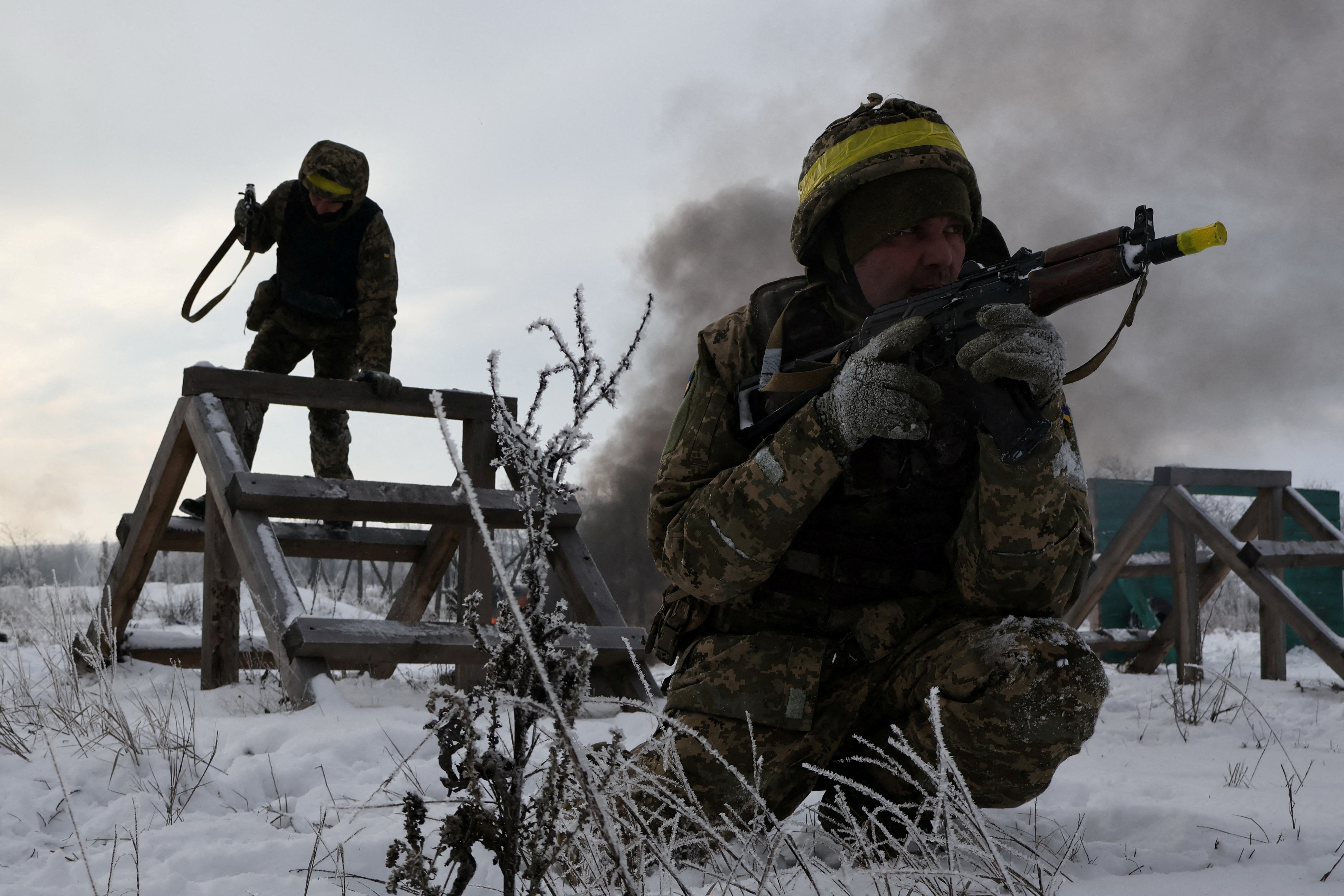 Recruits attend military exercises in a snow-covered field.