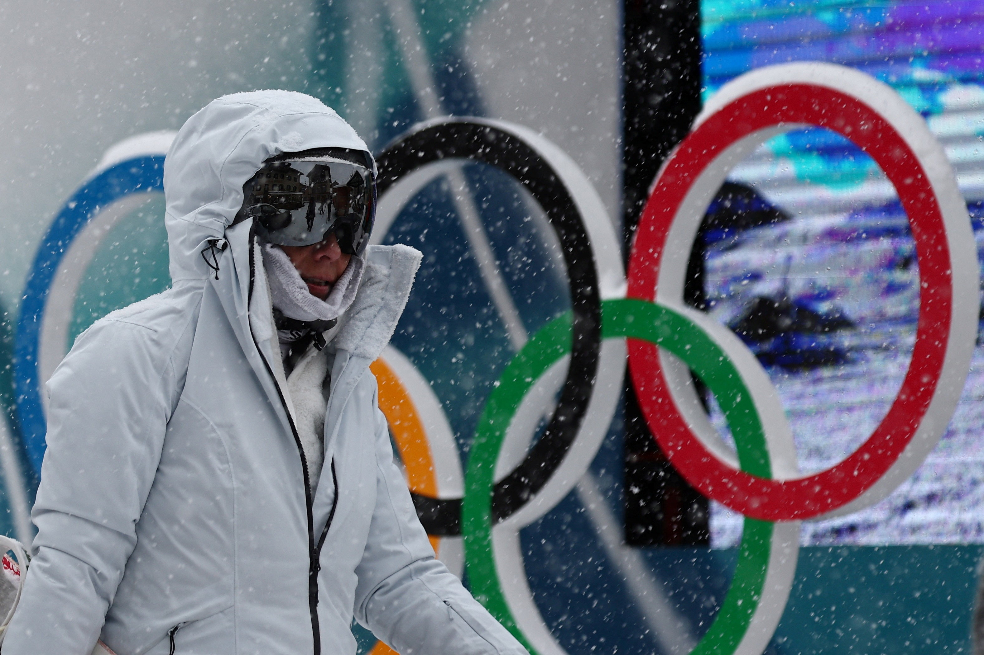 A skier walks past the Olympic Rings in Livigno, which will host all the Milano Cortina Winter Olympic Snowboard and Freestyle Skiing events
