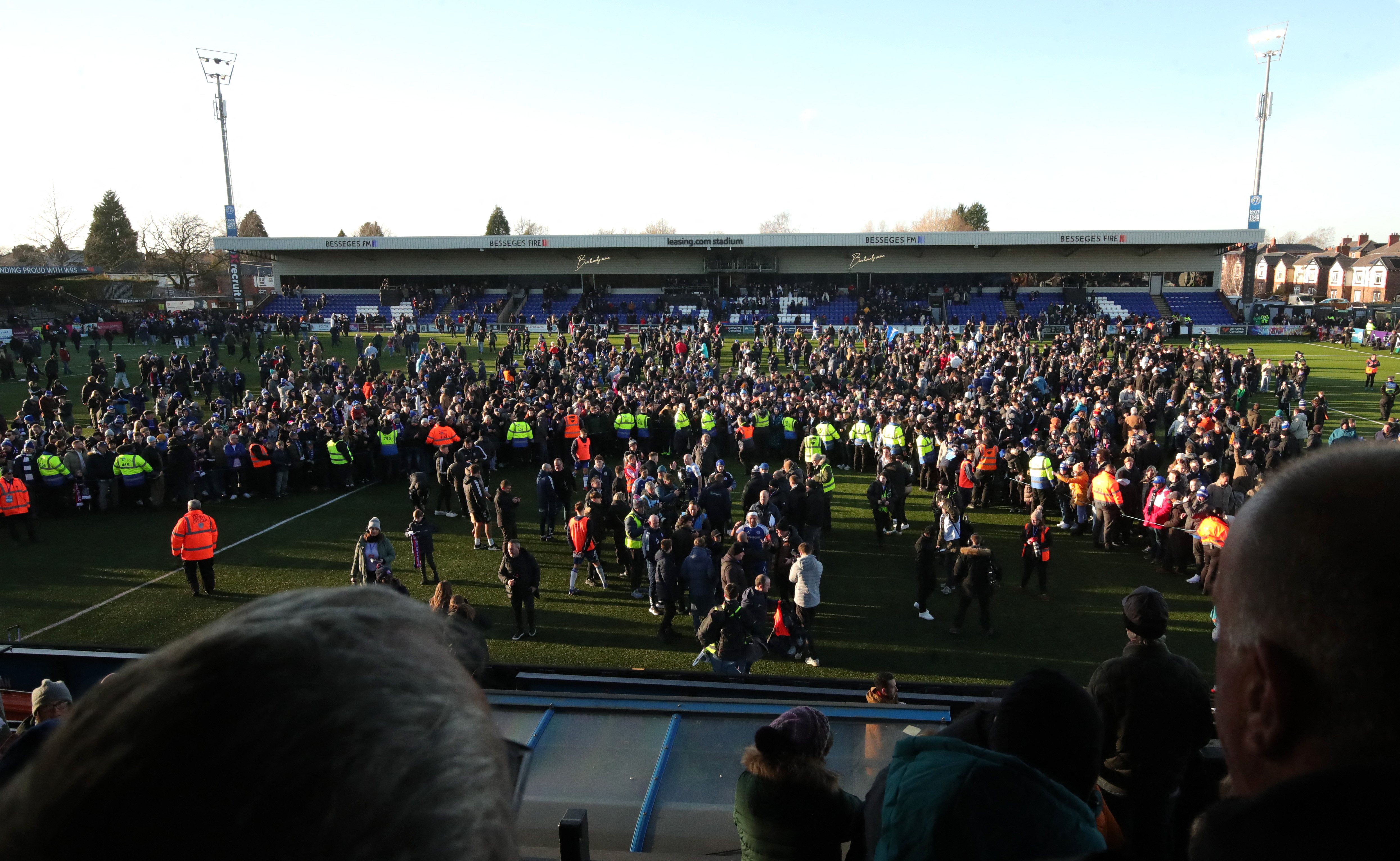 General view as Macclesfield F.C.'s fans and players celebrate on the pitch after the match