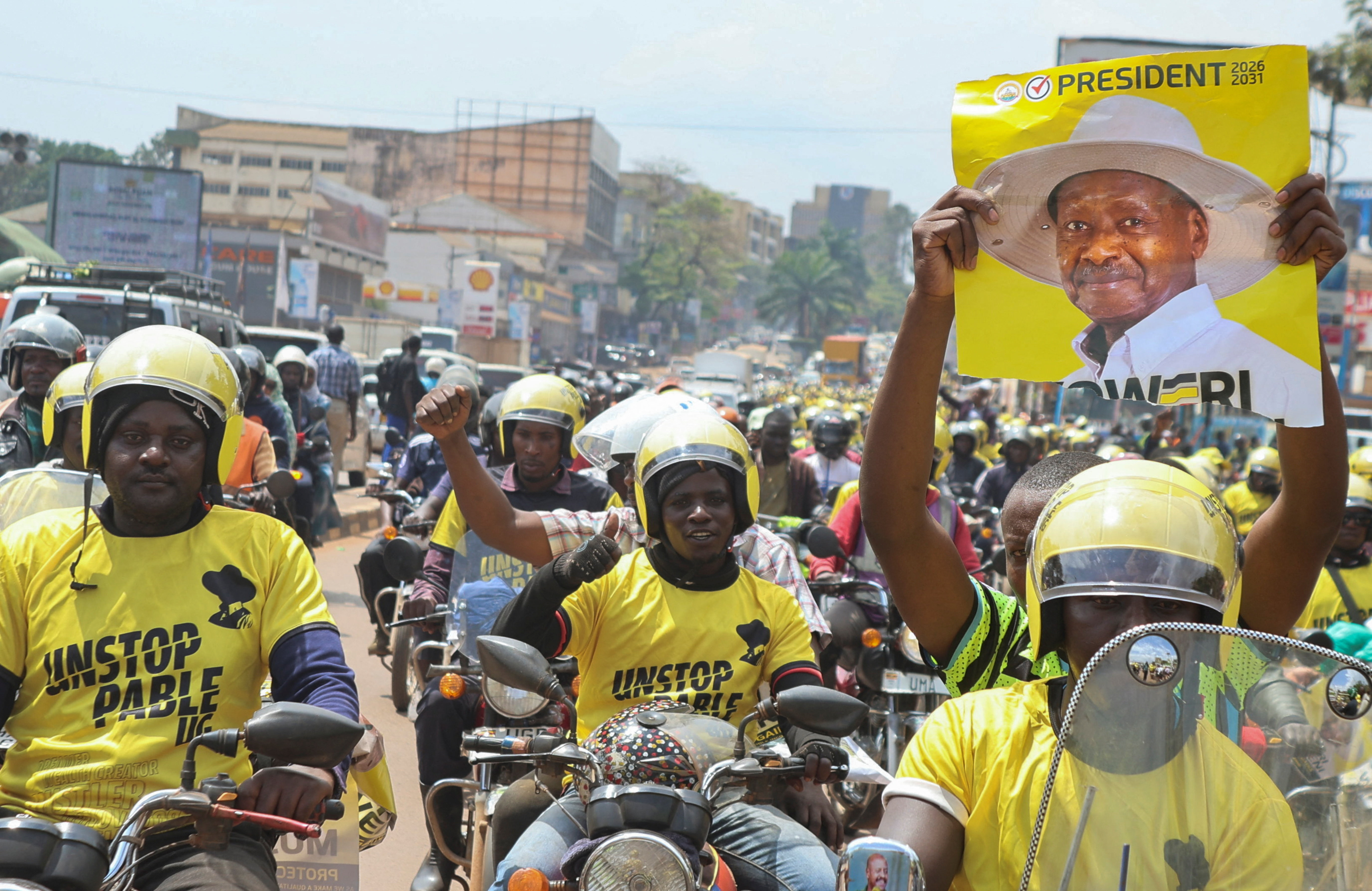 Supporters of Uganda's President and the leader of ruling National Resistance Movement (NRM) party, Yoweri Museveni, ride their bikes along the street before attending his campaign rally in Kampala, Uganda January 13, 2026. REUTERS/Michael Muhati