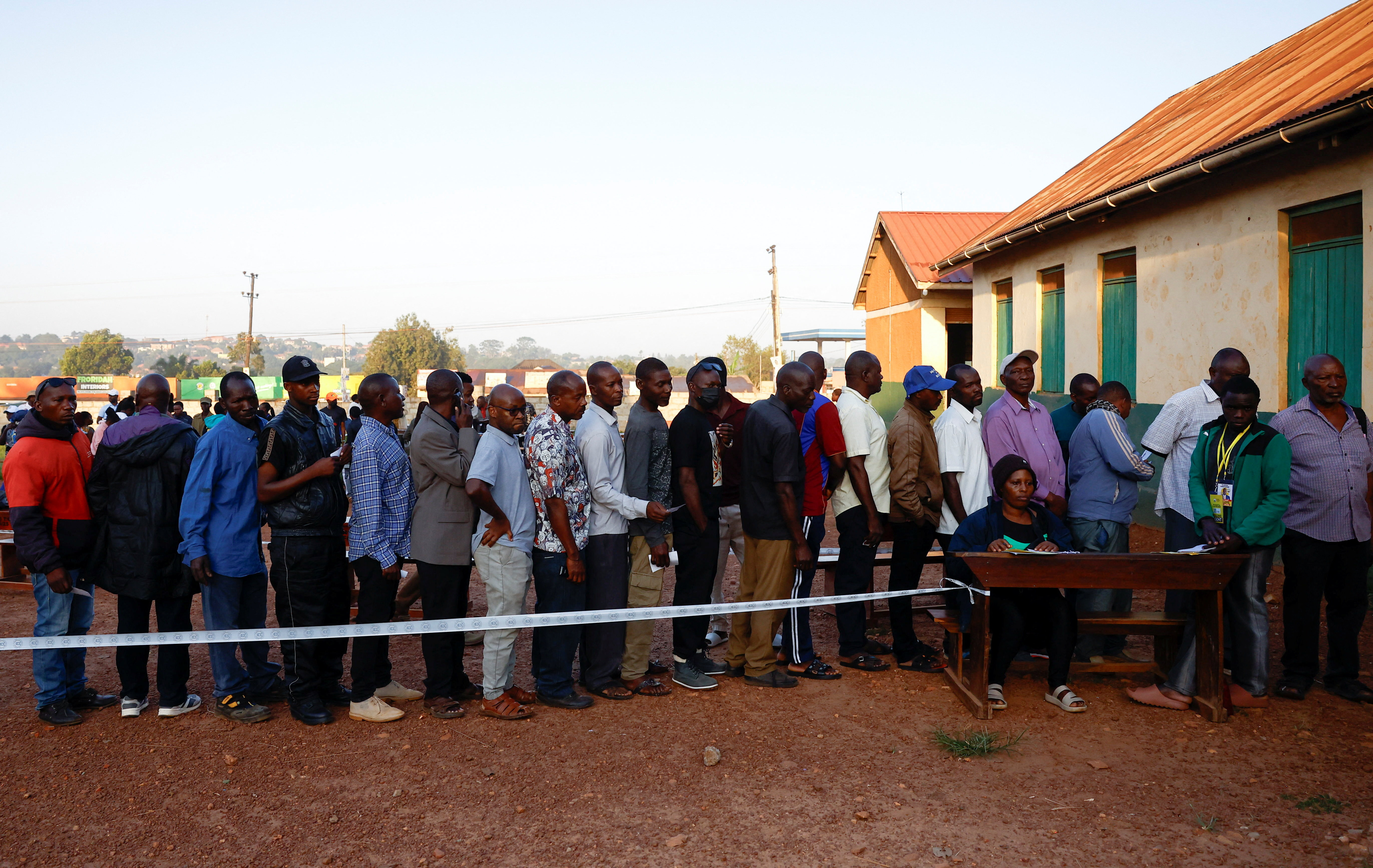 Ugandan voters queue at a polling station before the opening of the general election in Wampeewo, Wakiso District, Uganda