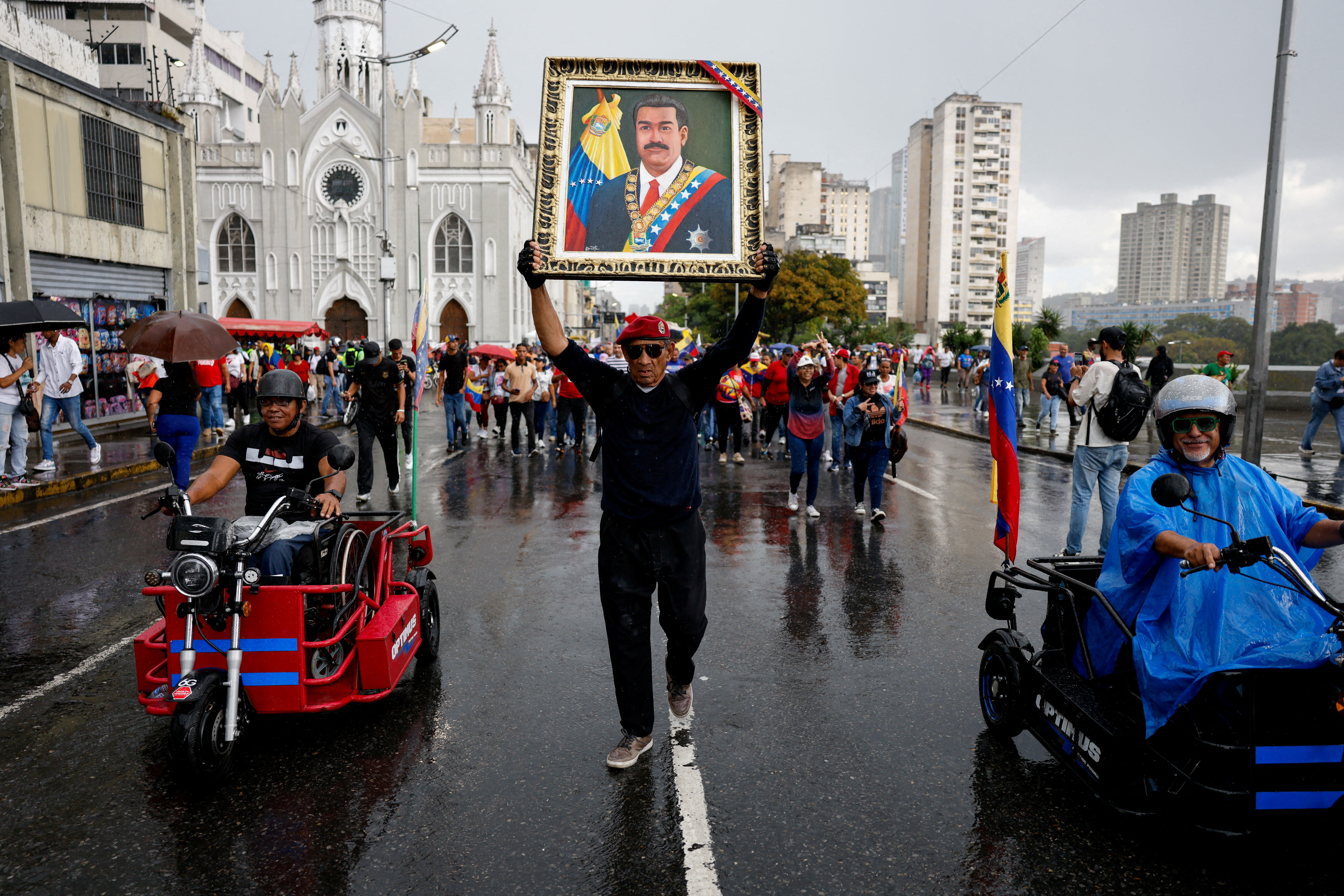 A demonstrator holds a portrait depicting ousted President Nicolas Maduro, as supporters of Venezuela's government march during a rally to demand the release of Maduro and his wife Cilia Flores, following their capture by U.S. forces during recent U.S. strikes on the country, in Caracas,