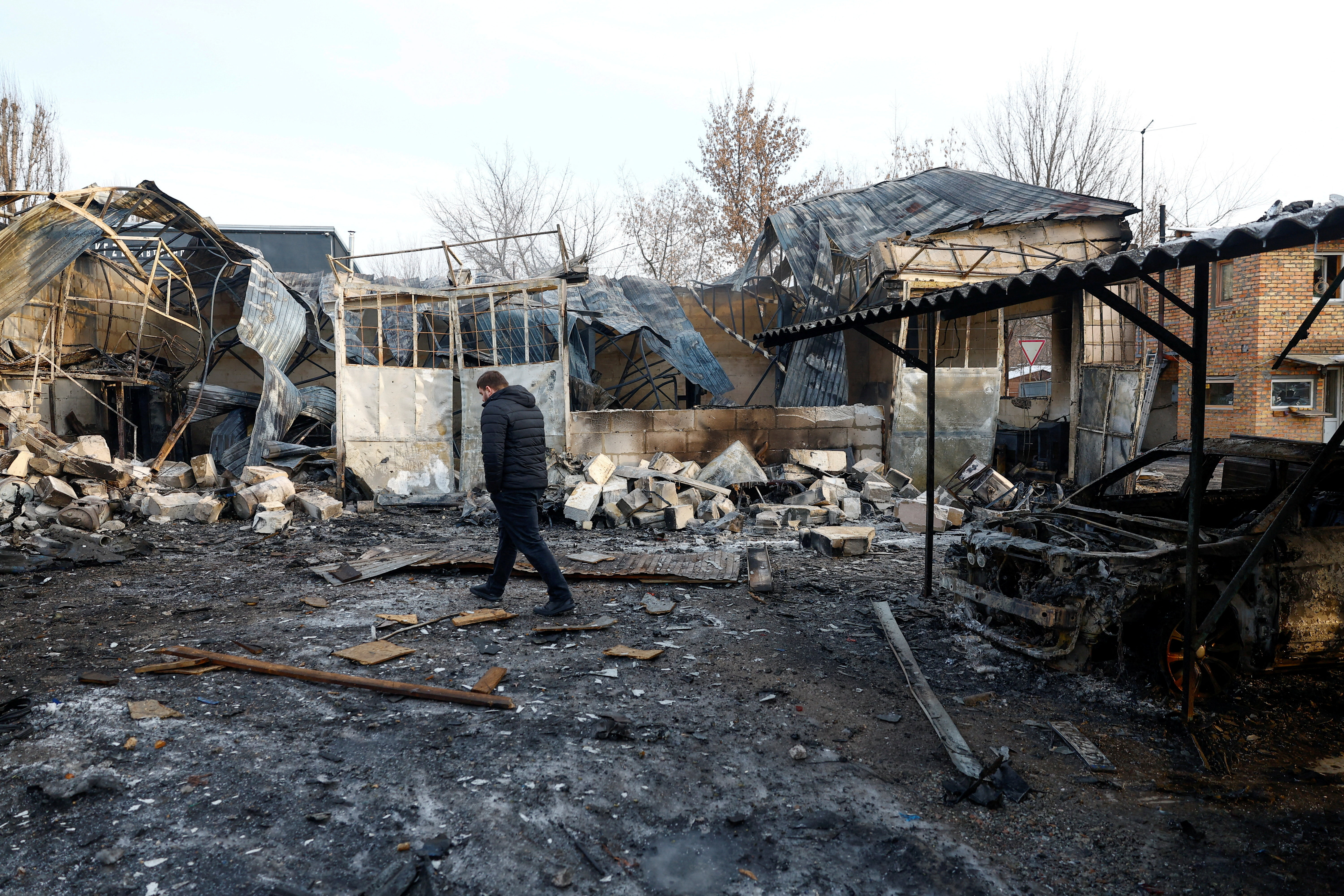A resident inspects a compound of car workshop and garage hit during Russian overnight drone and missile strikes, amid Russia's attack on Ukraine, in Kyiv, Ukraine January 24, 2026. REUTERS/Valentyn Ogirenko