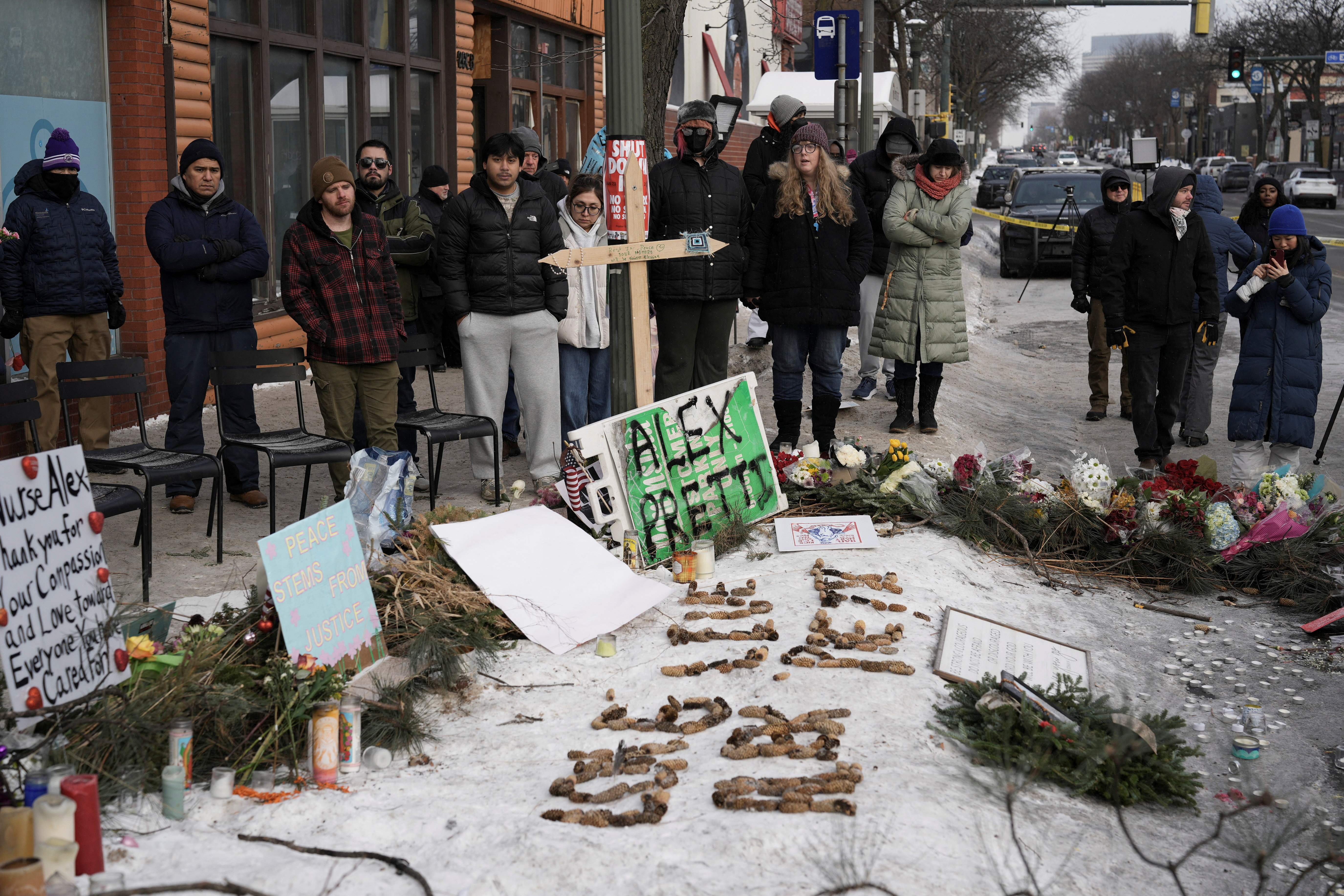 People gather at a makeshift memorial at the site where Alex Pretti was shot dead by federal immigration agents in Minneapolis, Minnesota