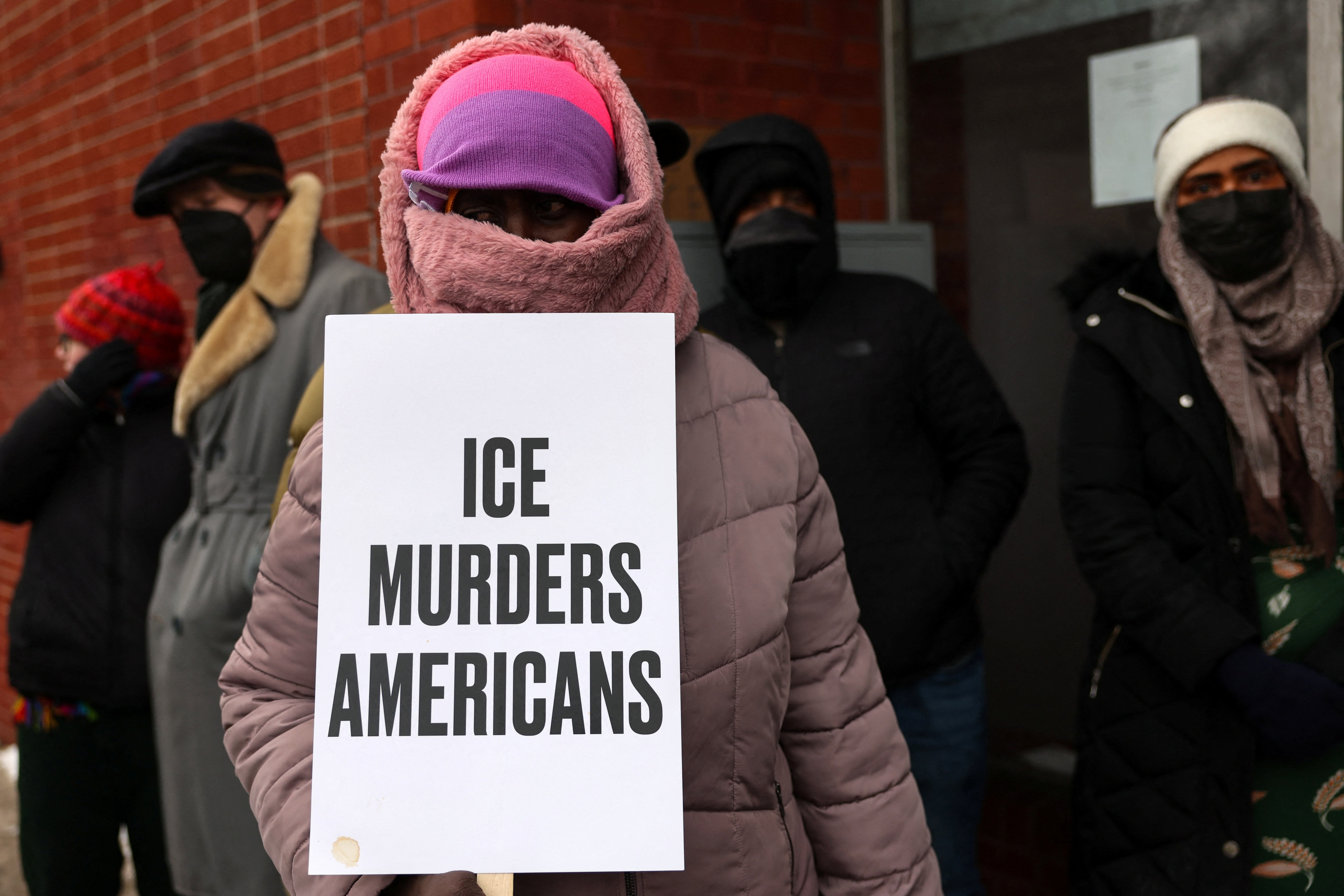 People stand at the makeshift memorial site, where a man identified as Alex Pretti was fatally shot by federal immigration agents trying to detain him, in Minneapolis, Minnesota, U.S., January 26, 2026. REUTERS/Shannon Stapleton