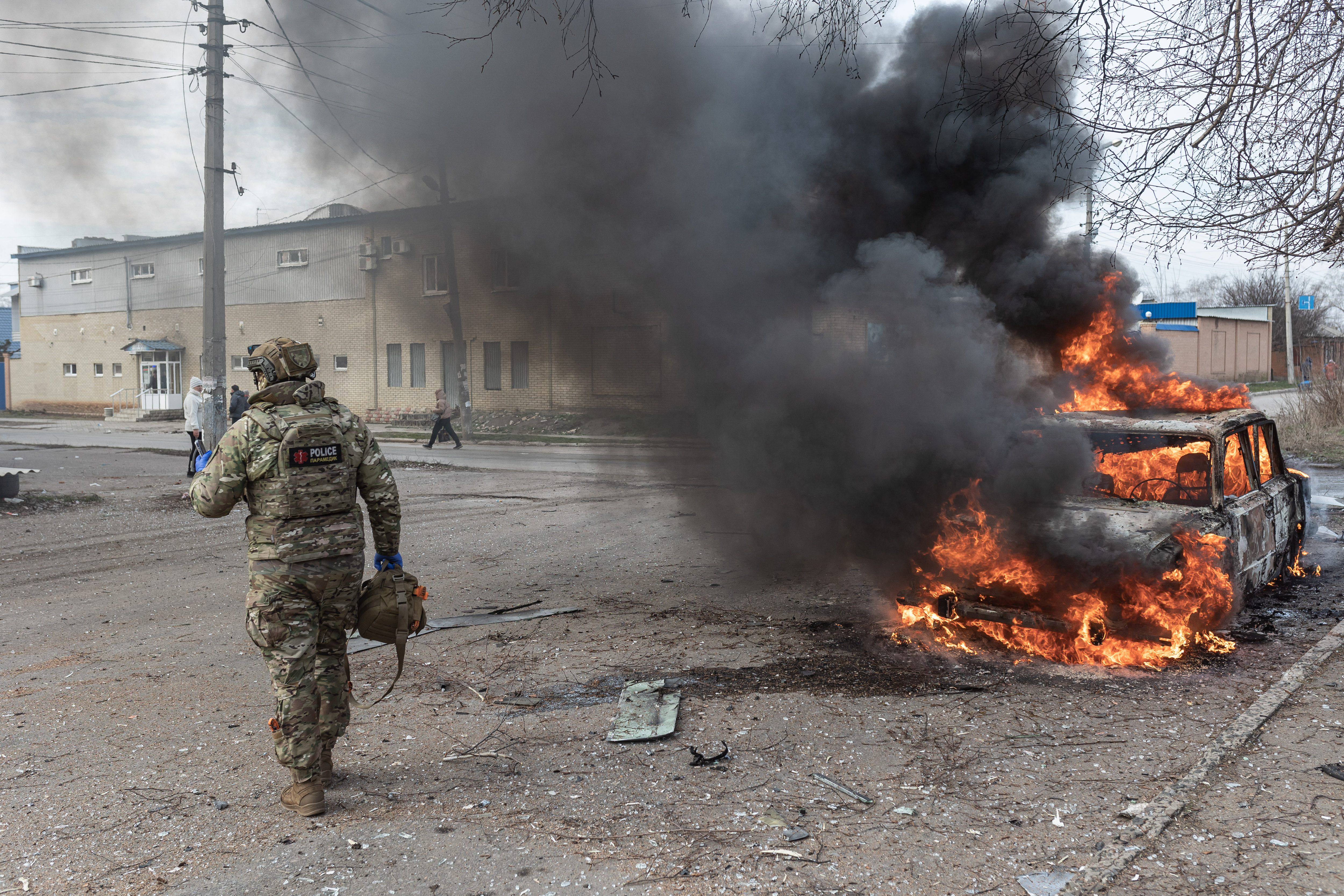 DRUZHKIVKA, UKRAINE - JANUARY 13: Paramedics rush to the scene as smoke and flames rise from a car after being hit by a Russian FPV drone in Druzhkivka, Ukraine on January 13, 2026. A civilian in the car targeted in the drone attack was injured. ( Diego Herrera Carcedo - Anadolu Agency )