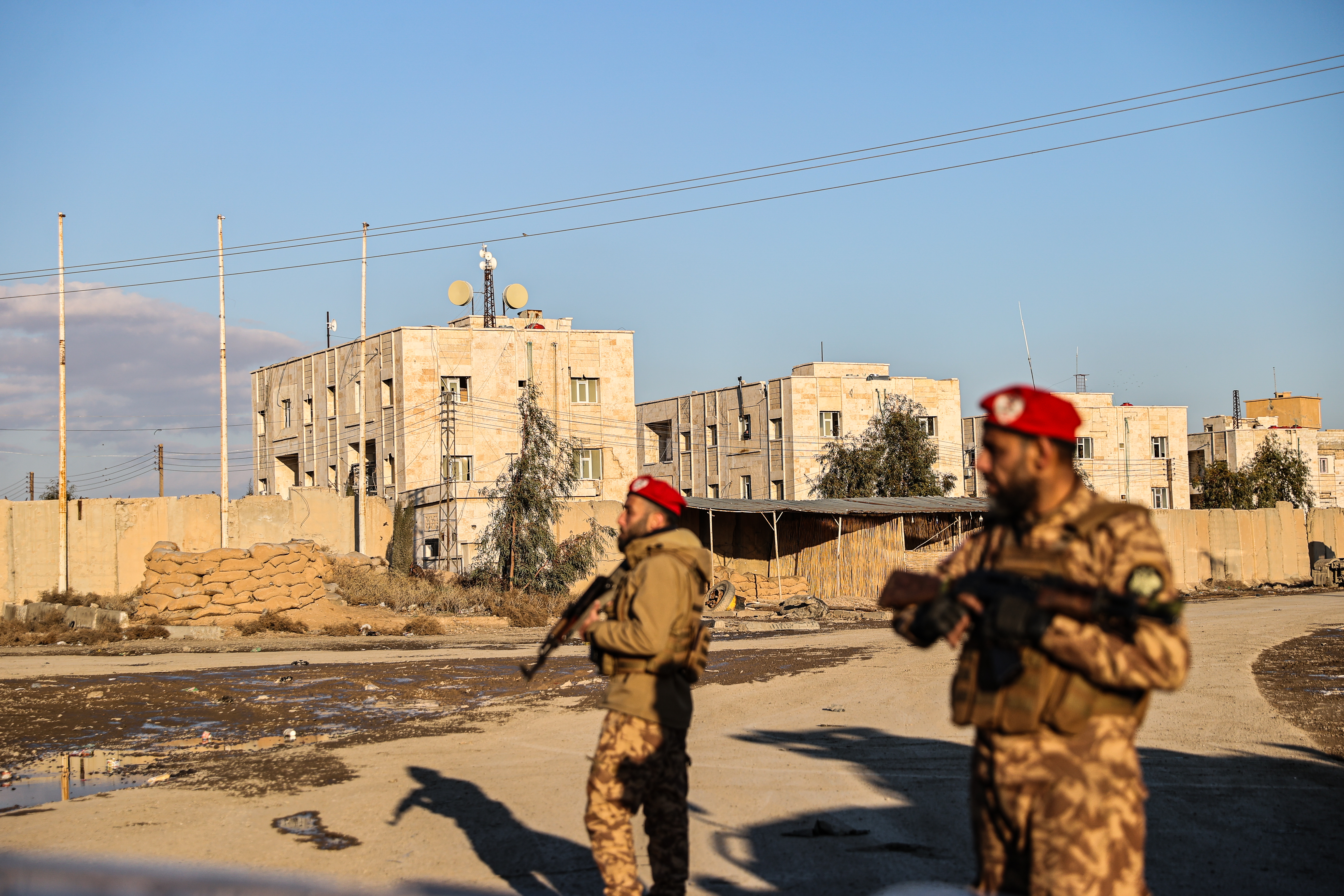 Soldiers stand guard in front of a prison.