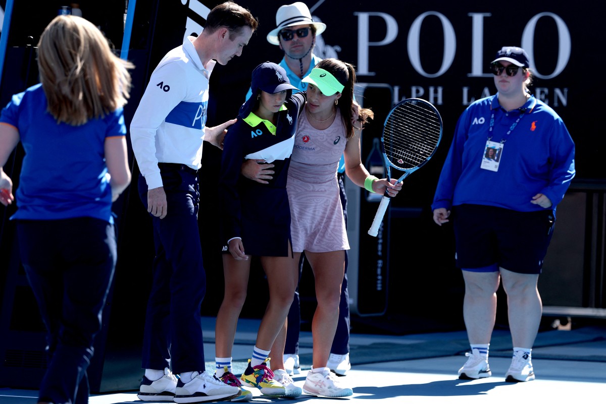 Turkeys Zeynep Sonmez assists a ball kid after she fainted during Sonmezs womens singles match against Russias Ekaterina Alexandrova on day one of the Australian Open in Melbourne on January 18, 2026. (Photo by DAVID GRAY / AFP) / -- IMAGE RESTRICTED TO EDITORIAL USE - STRICTLY NO COMMERCIAL USE --