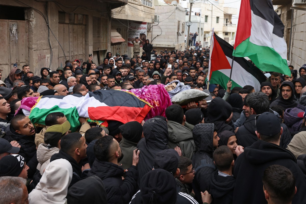 EDITORS NOTE: Graphic content / People carry the body of a Palestinian youth, who was allegedly killed on previous night in a raid by the Israeli security forces, during his funeral procession in the Al-Dahriya village on the outskirts of the Israeli occupied West Bank city of Hebron on January 28, 2026. Violence in the West Bank, which Israel has occupied since 1967, has soared since the Hamas attack on Israel triggered the Gaza war in October 2023. (Photo by HAZEM BADER / AFP)