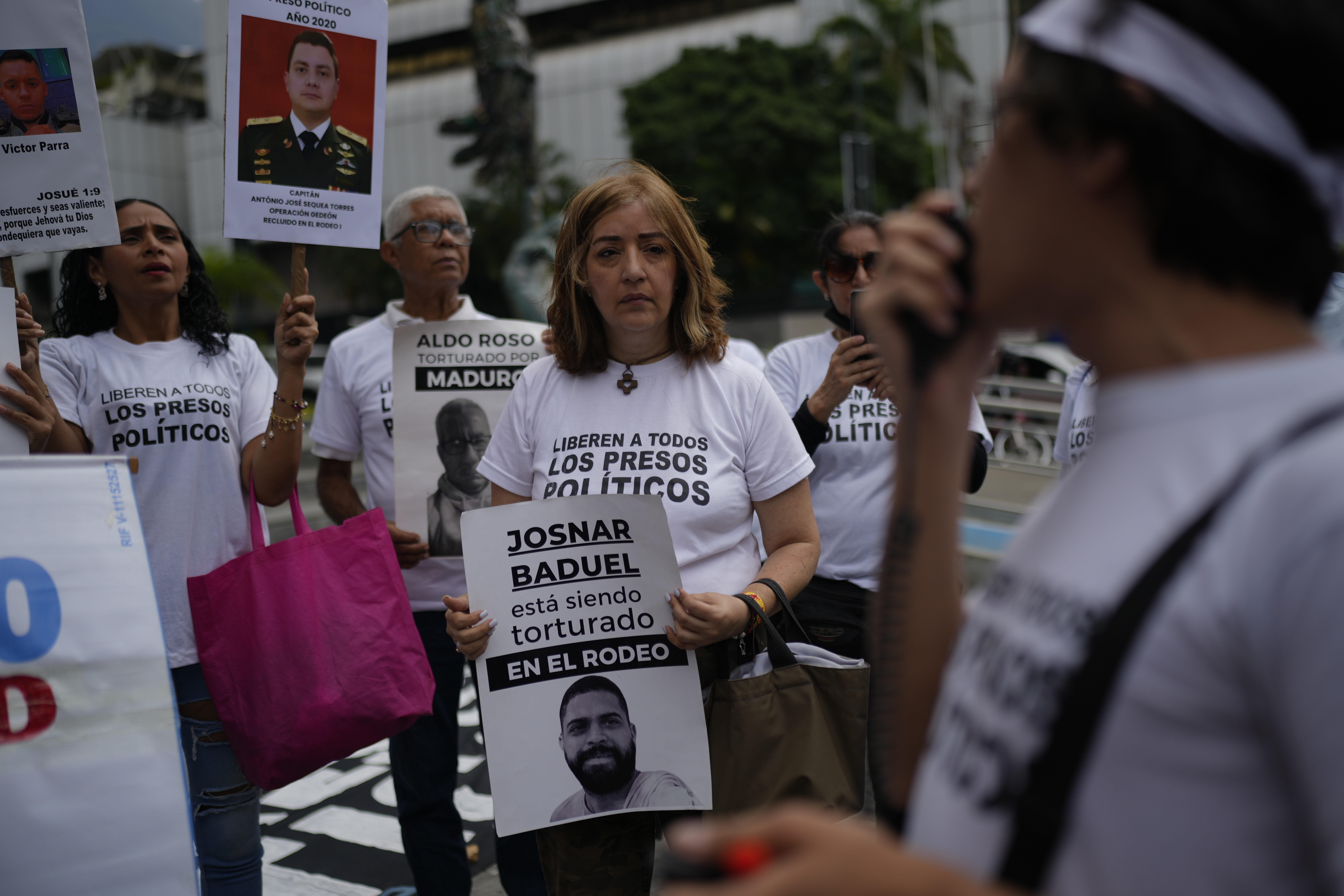 Protesters demand the end of isolation as a state policy and the release of what they consider political prisoners, outside the United Nations office in Caracas, Venezuela, Friday, March 28, 2025. The sign reads in Spanish "Josnar Baduel is being tortured in El Rodeo," referring to a prison. (AP Photo/Ariana Cubillos)