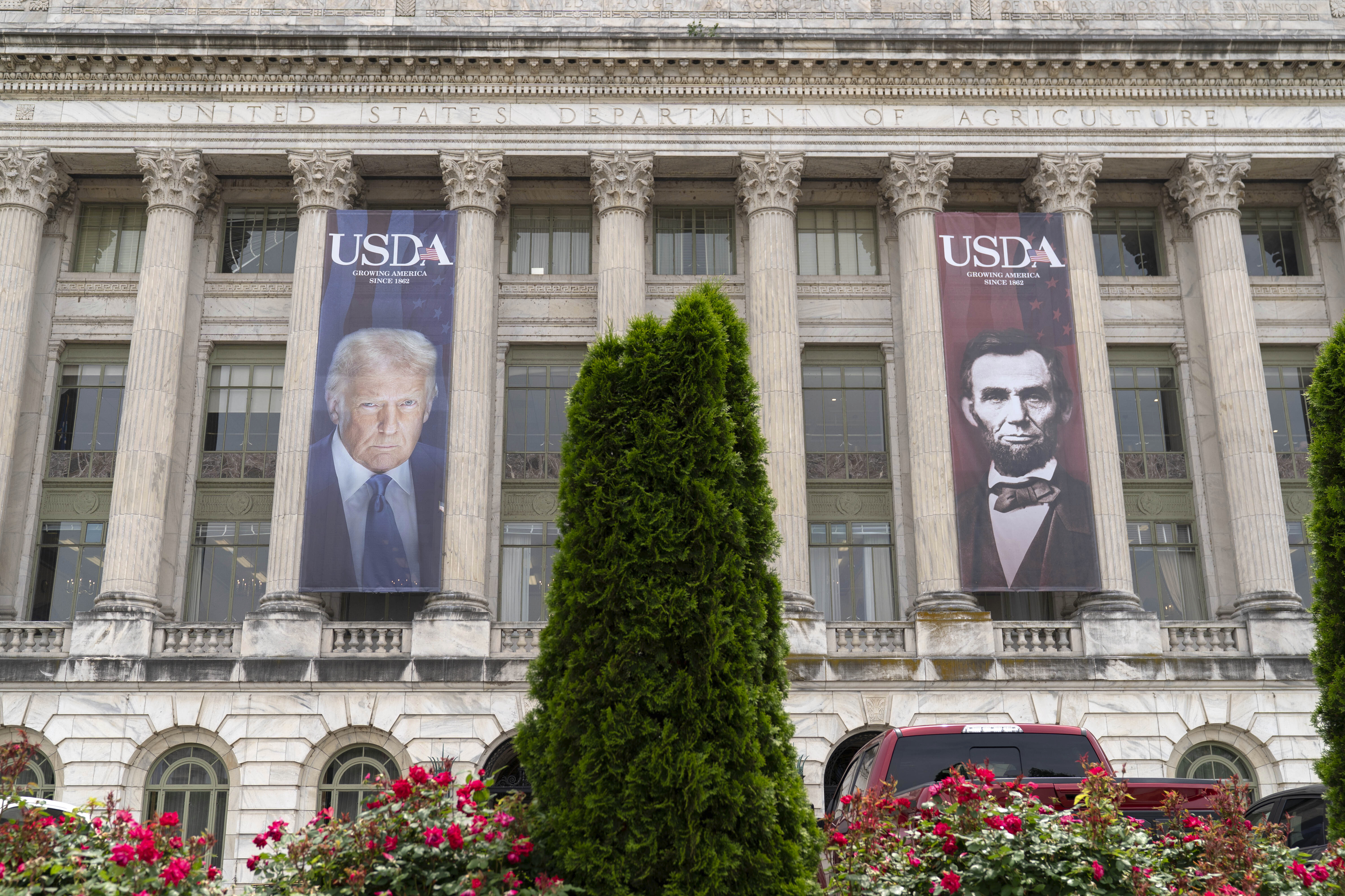Banners on the side of the Department of Agriculture show Trump's face next to Lincoln's