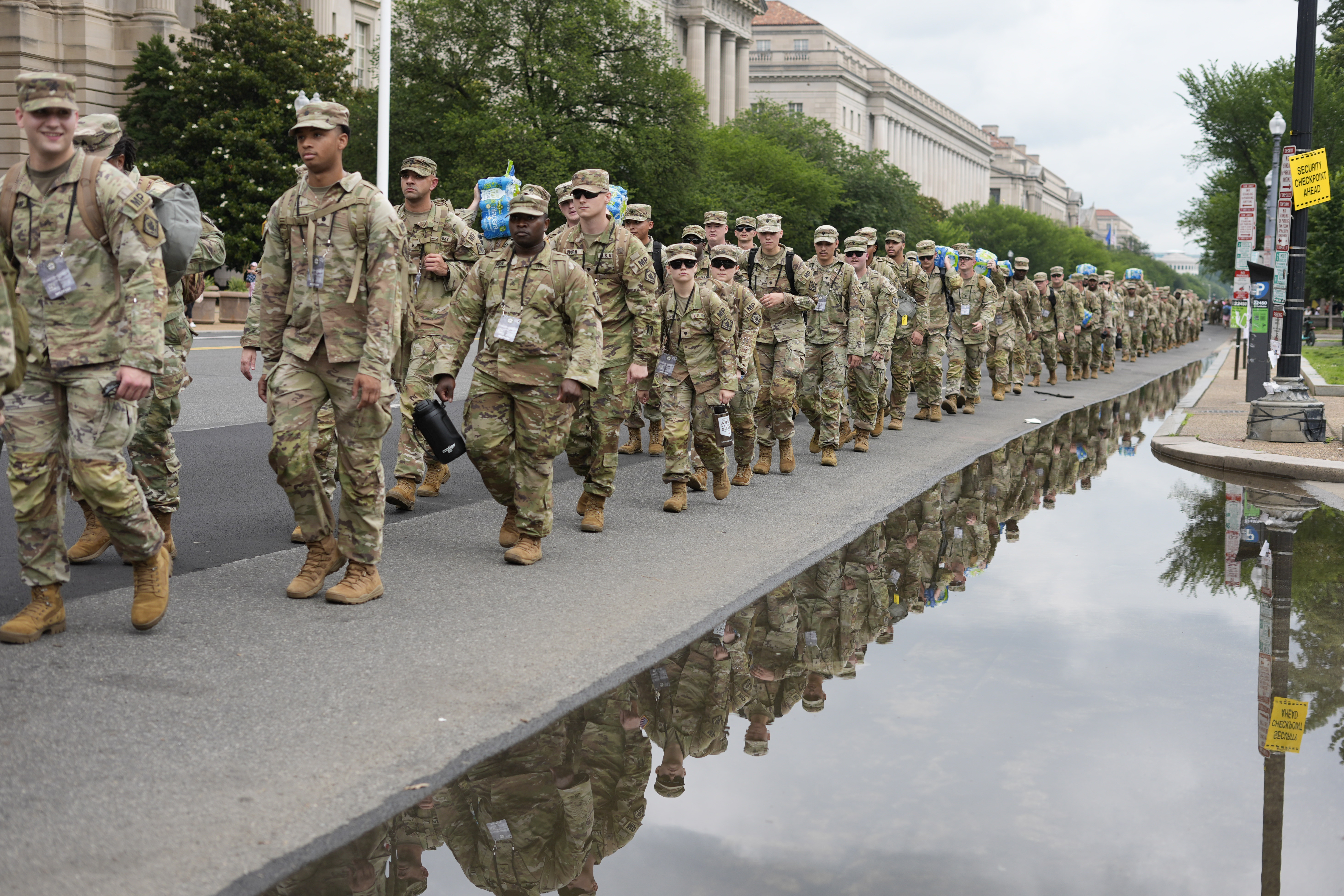 A line of soldiers walks along Constitution Ave
