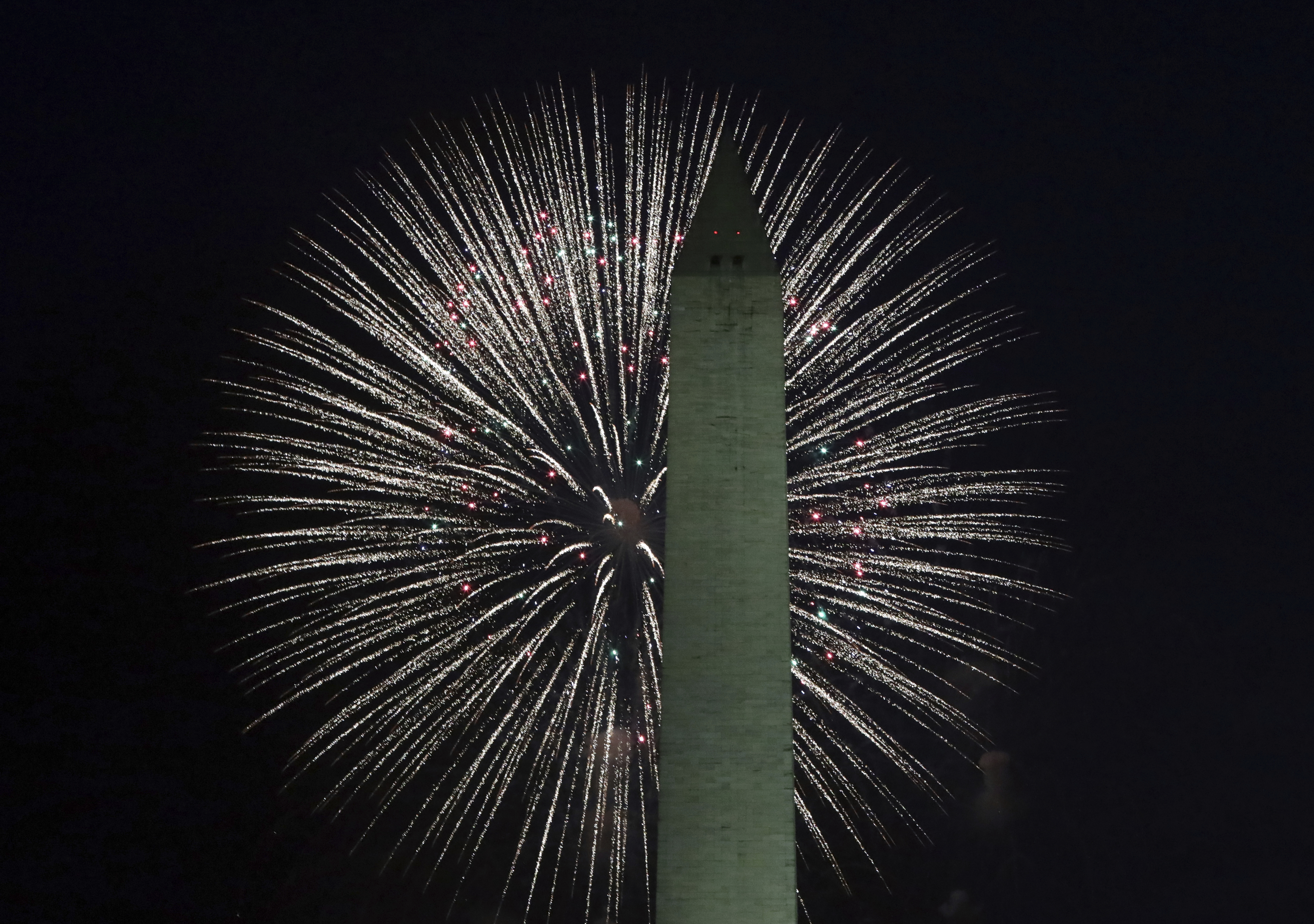 A firework behind the Washington Monument