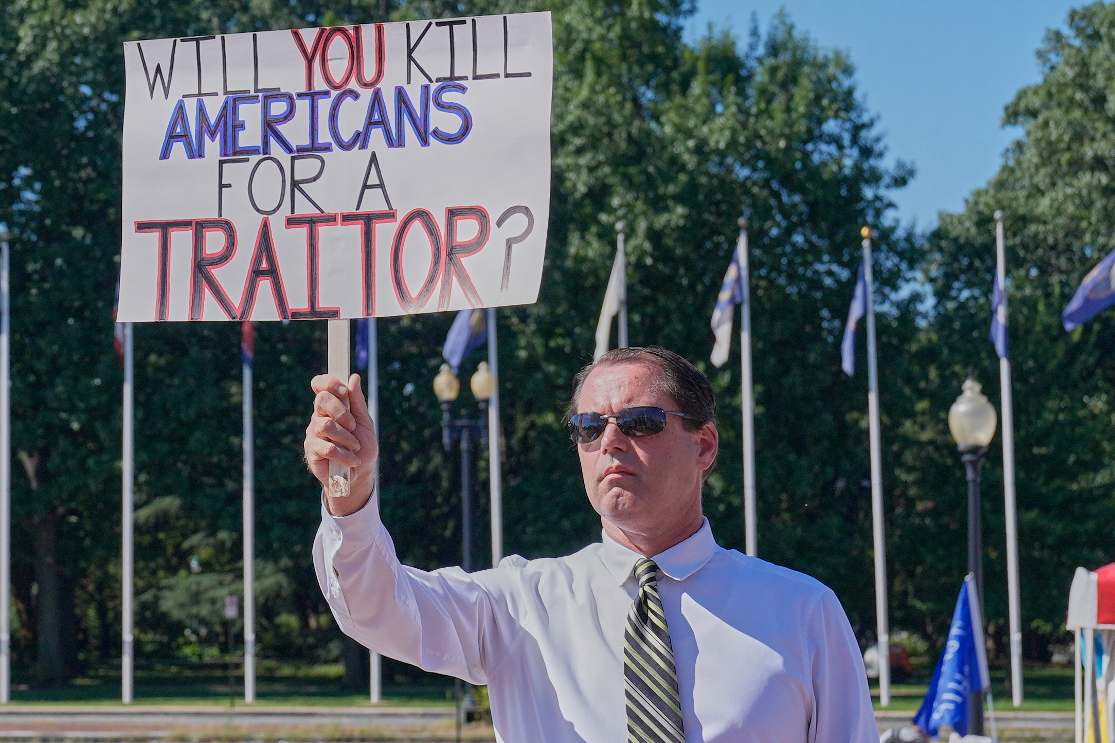 A protester holds a sign asking, "Will you kill Americans for a traitor?"