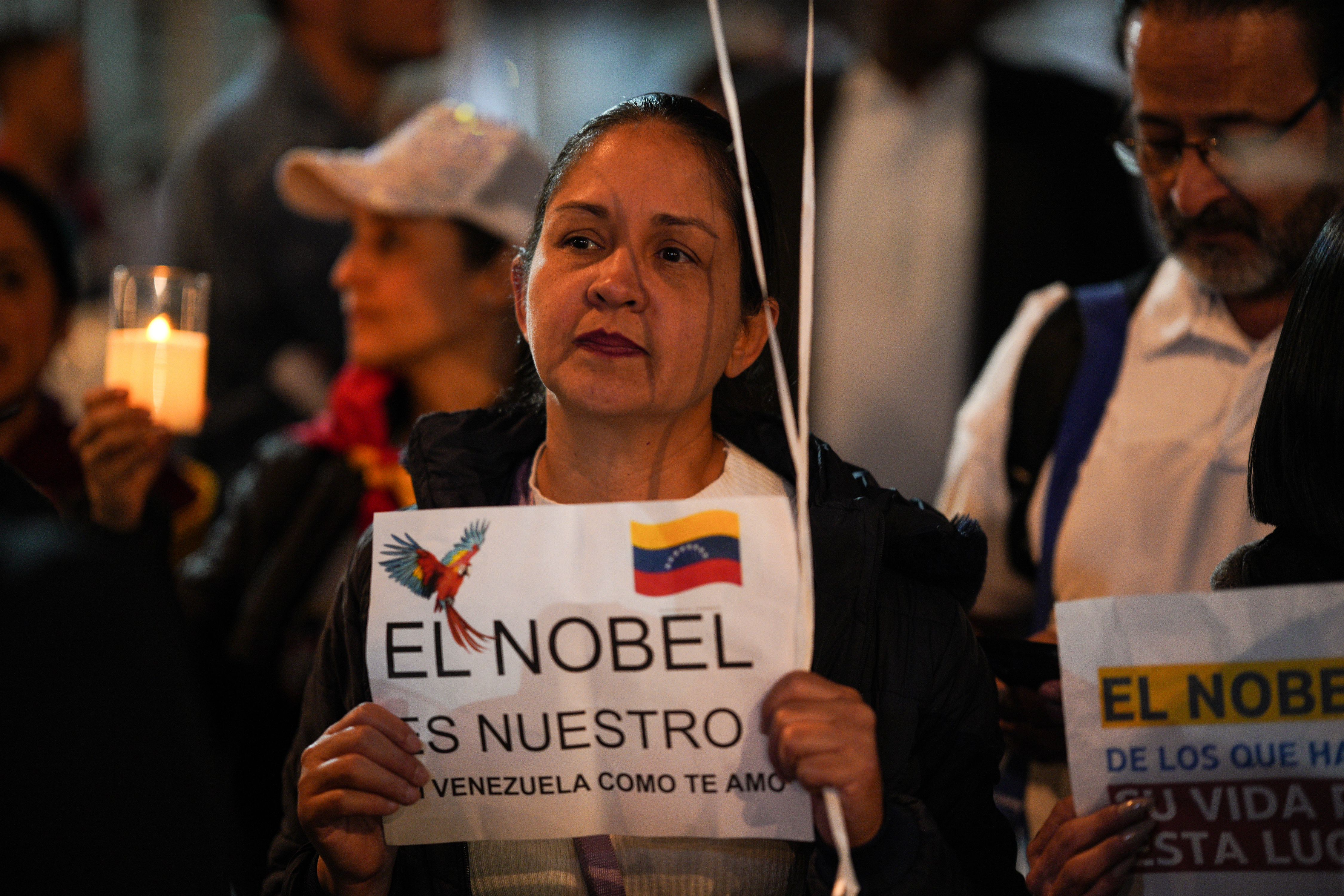 A supporter of Maria Corina Machado holds a sign that reads in Spanish, "The Nobel is ours."