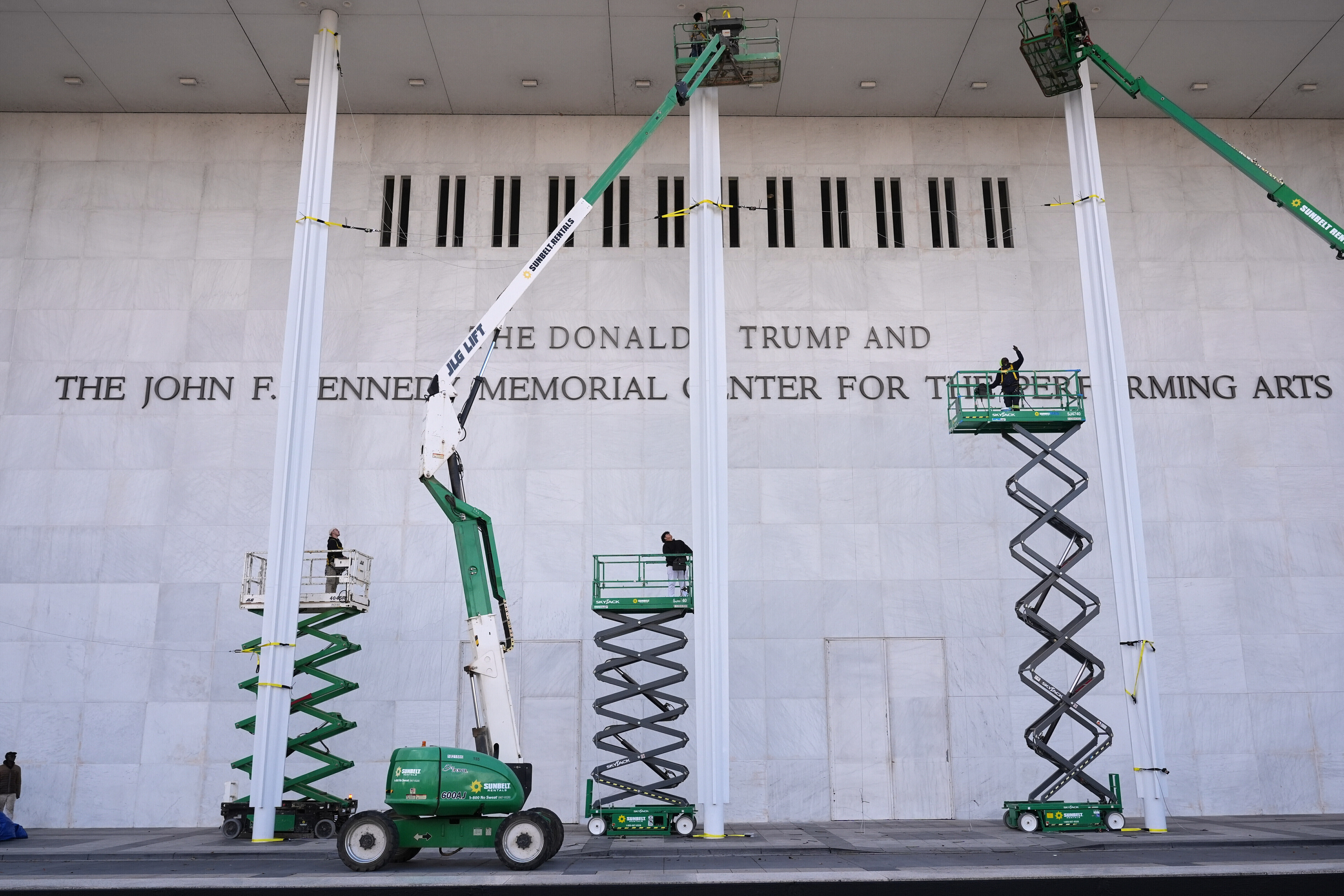 Construction crews install Donald Trump's name on the Kennedy Center.