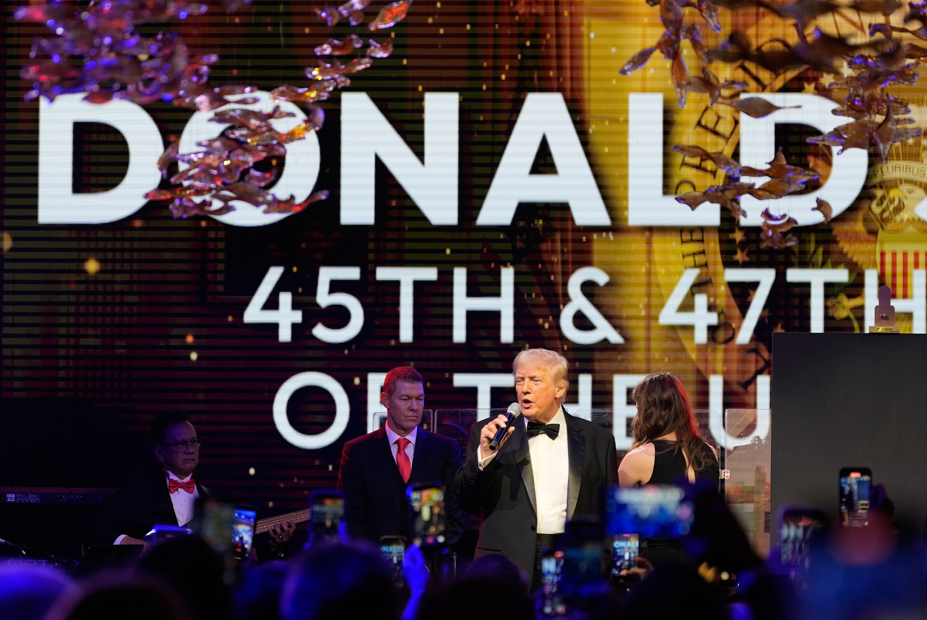 Donald Trump speaks at his New Year's Eve party, under a sign bearing his name