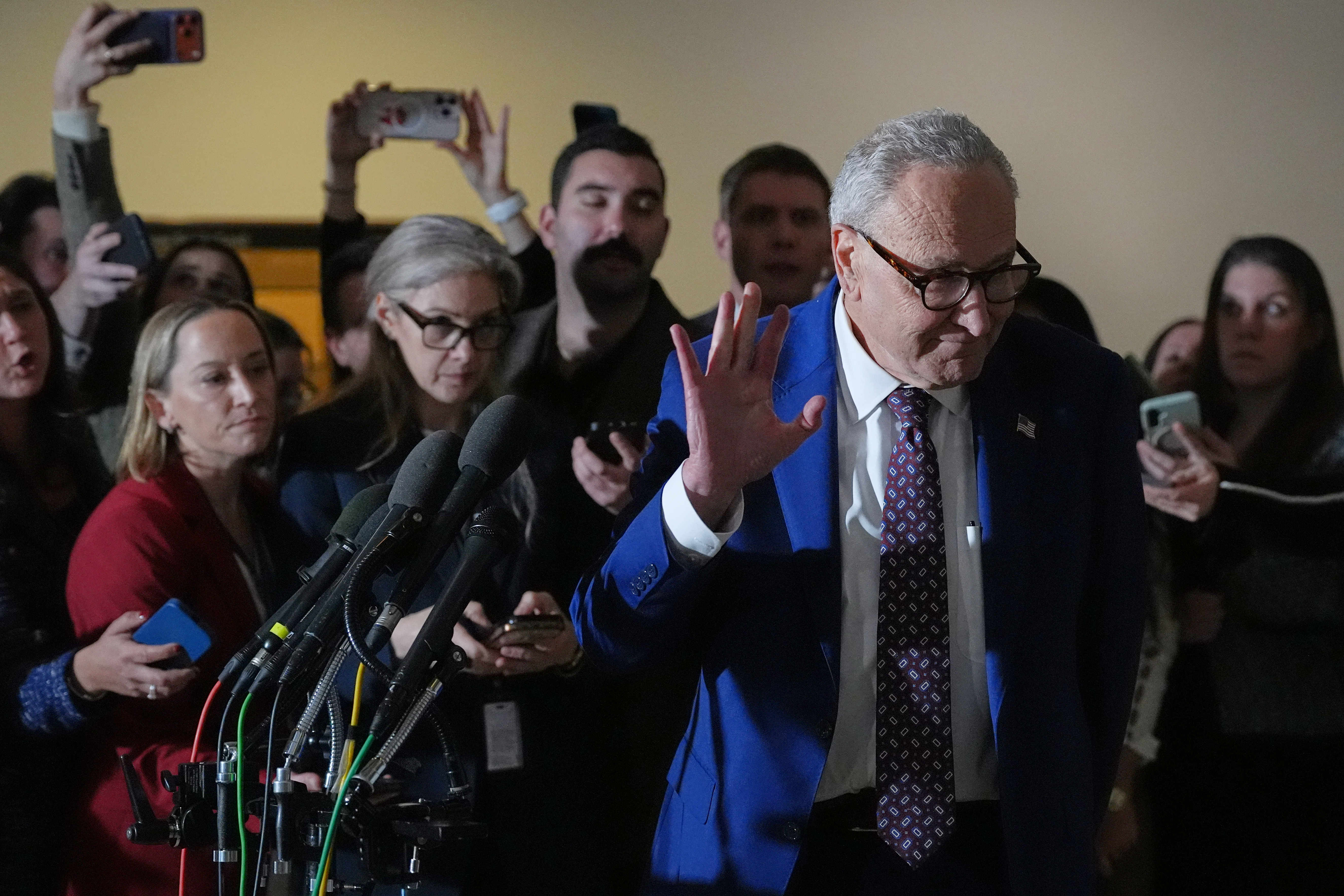 Chuck Schumer waves as he turns away from reporters