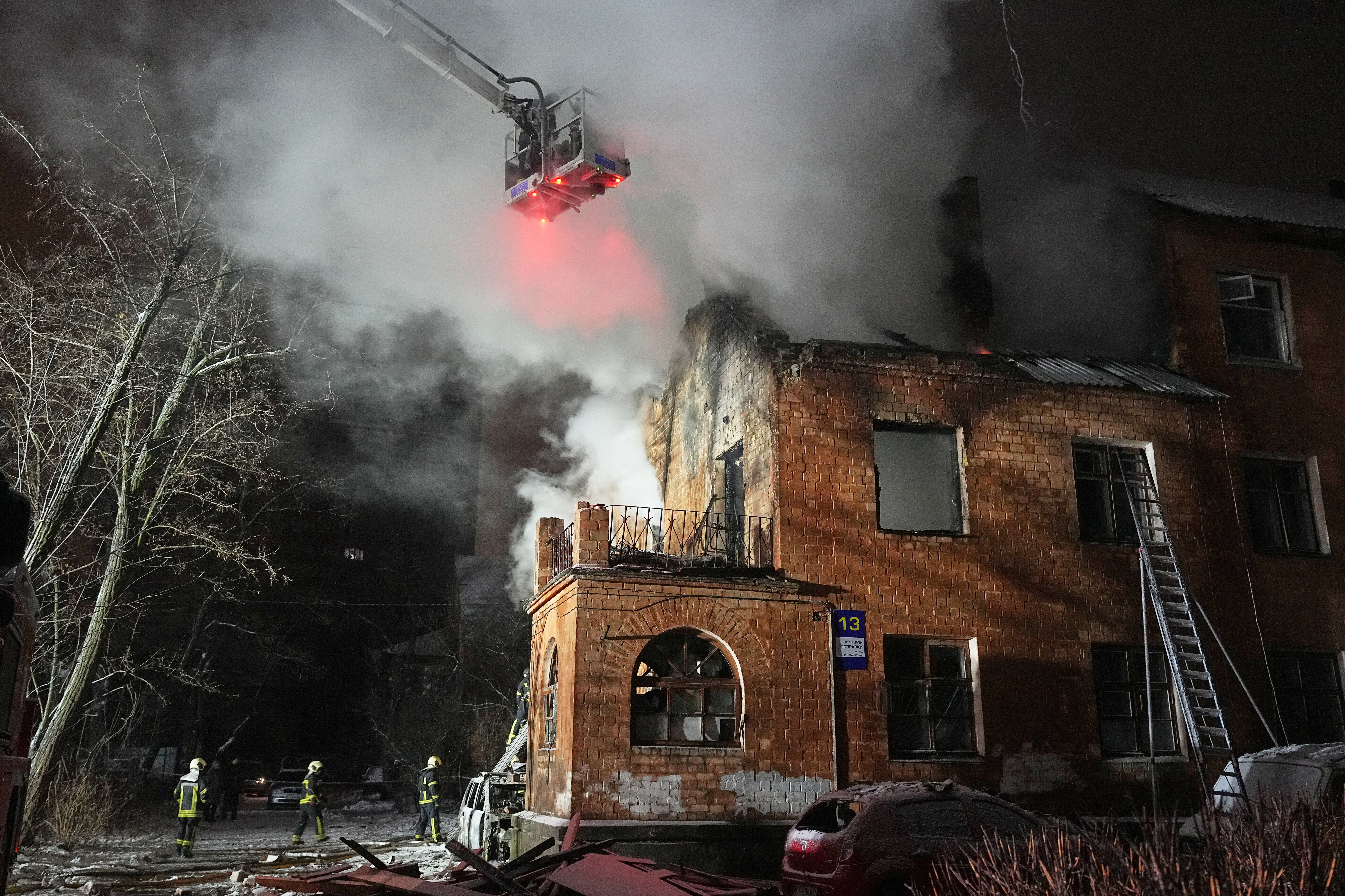 Rescue workers try to put out a fire in Ukraine after Russian attacks.
