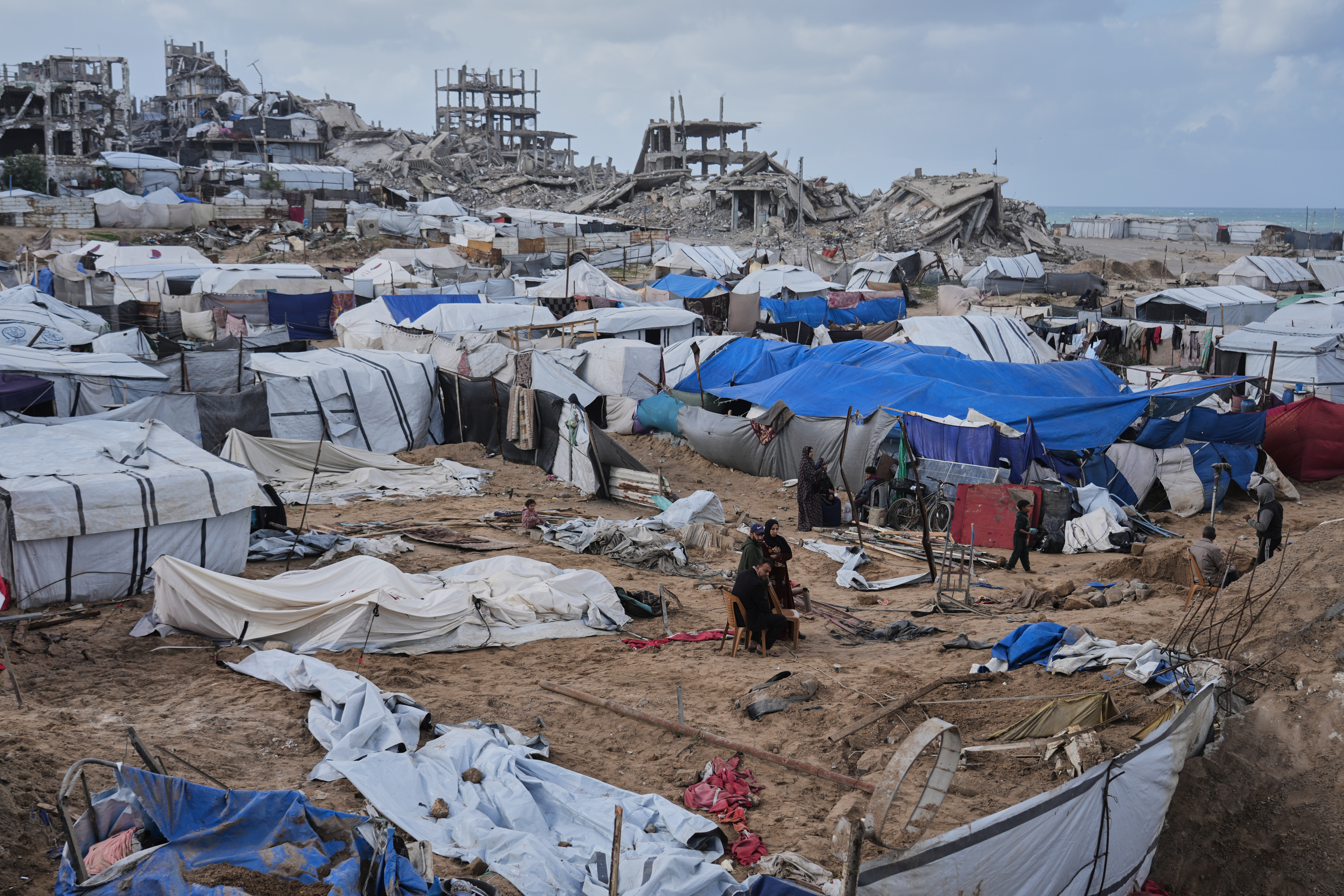Palestinians inspect damaged tents at a displacement camp following an Israeli strike in Gaza City