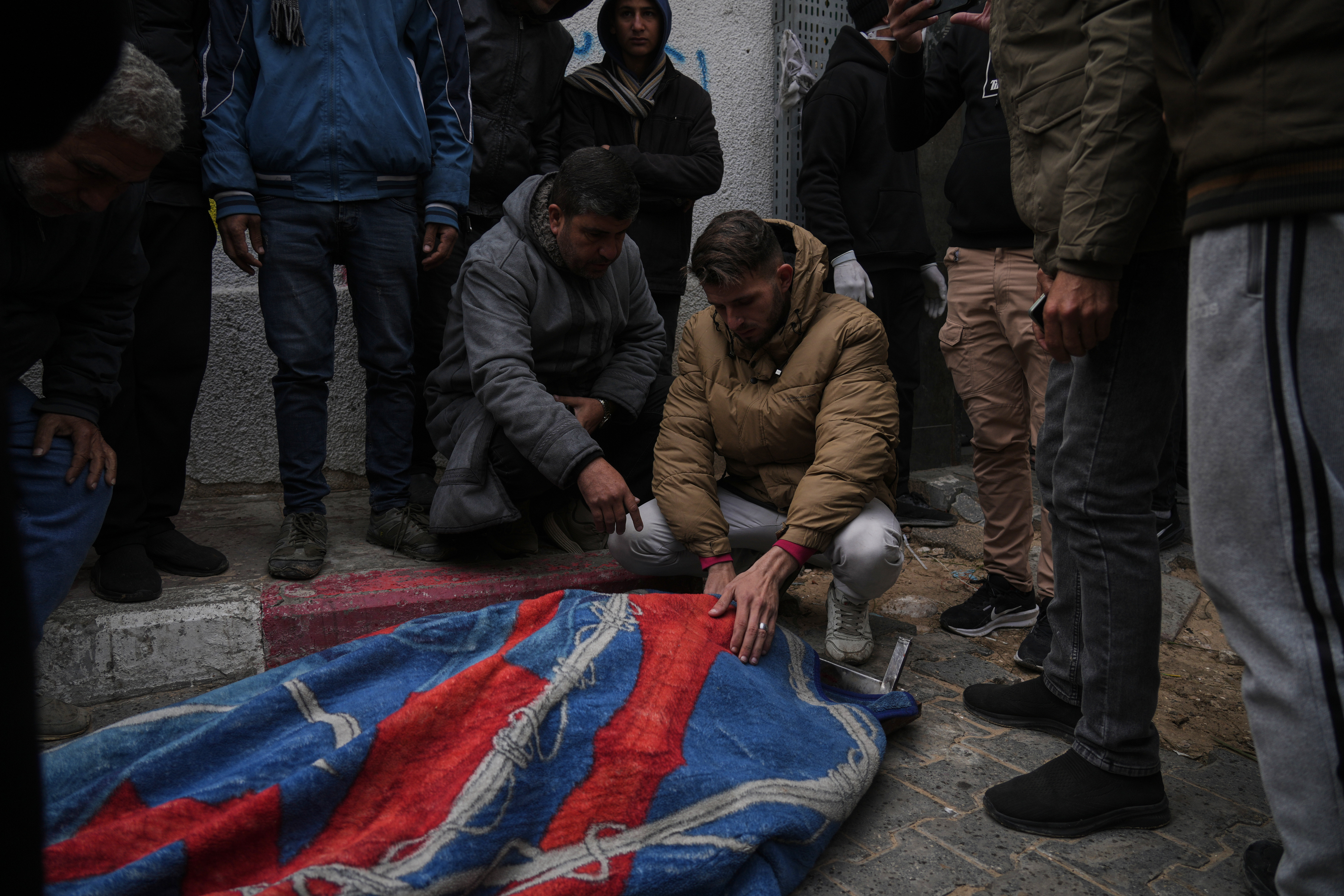 Members of the Hamouda family bid farewell to relatives who died when a damaged building collapsed onto their tents during a storm of wind and rain, at Al-Shifa Hospital