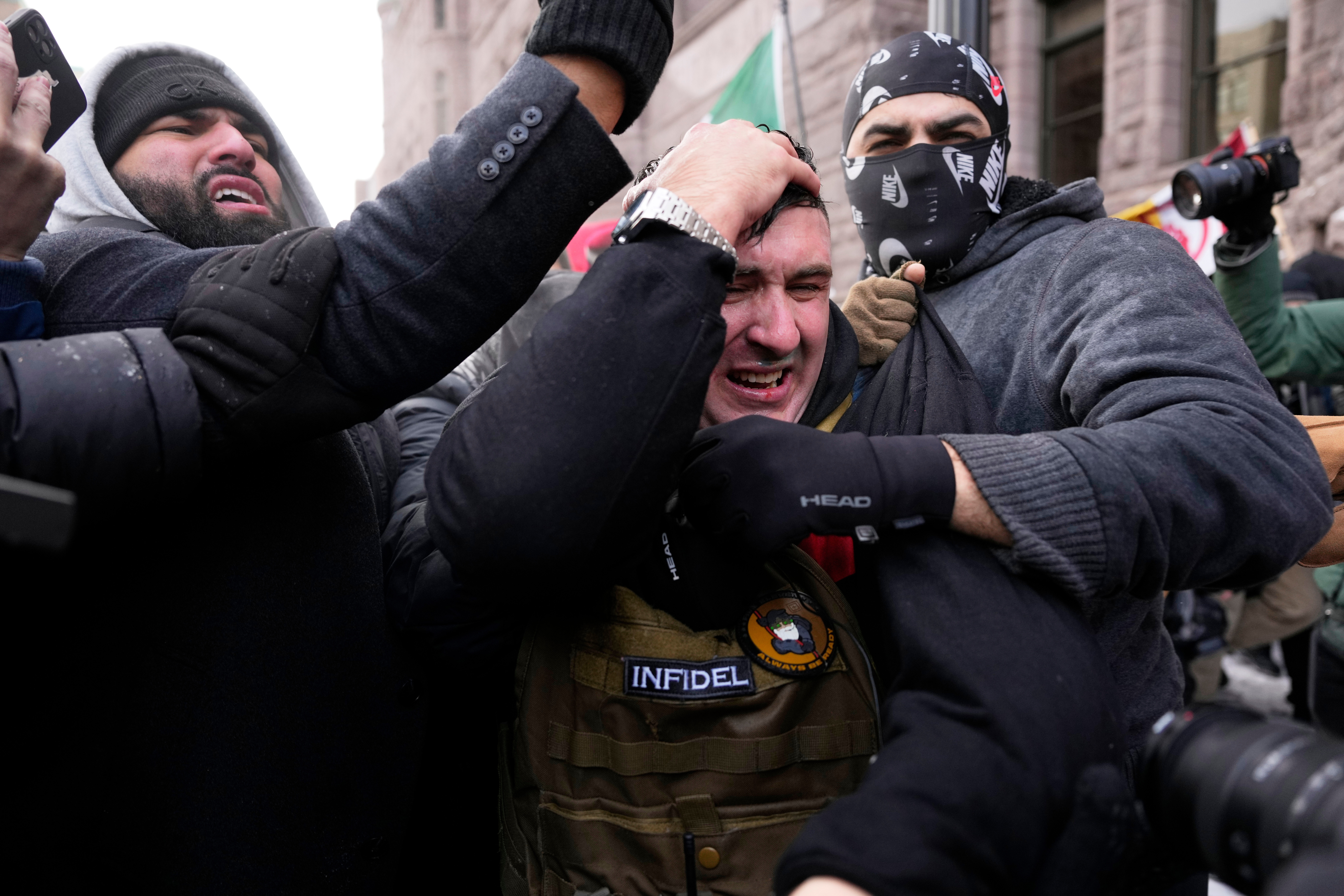 Jake Lang clutches his head as he leaves a rally near Minneapolis City Hall, Minnesota, US