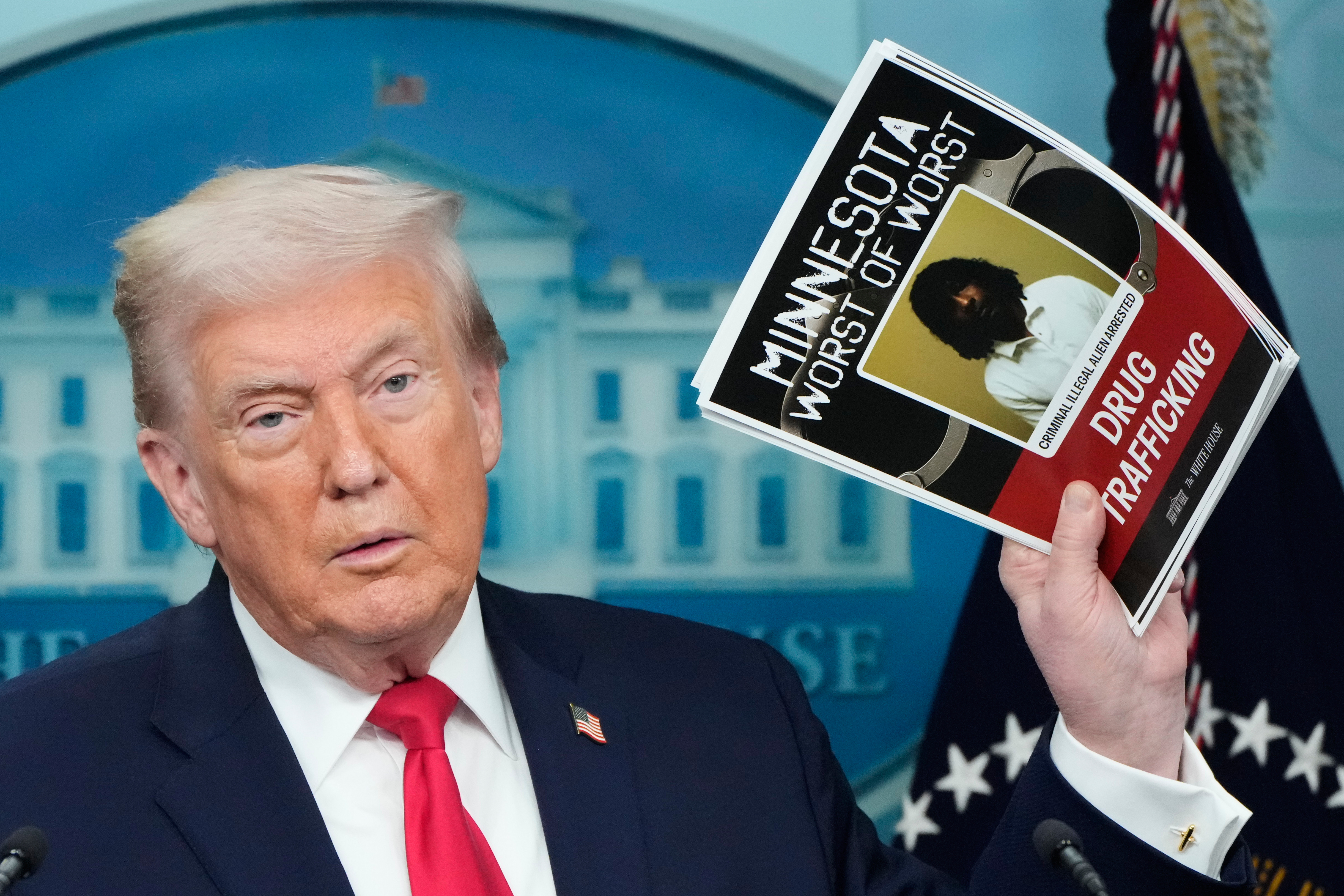 Trump lifts a printout that reads, "Minnesota Worst of Worst".