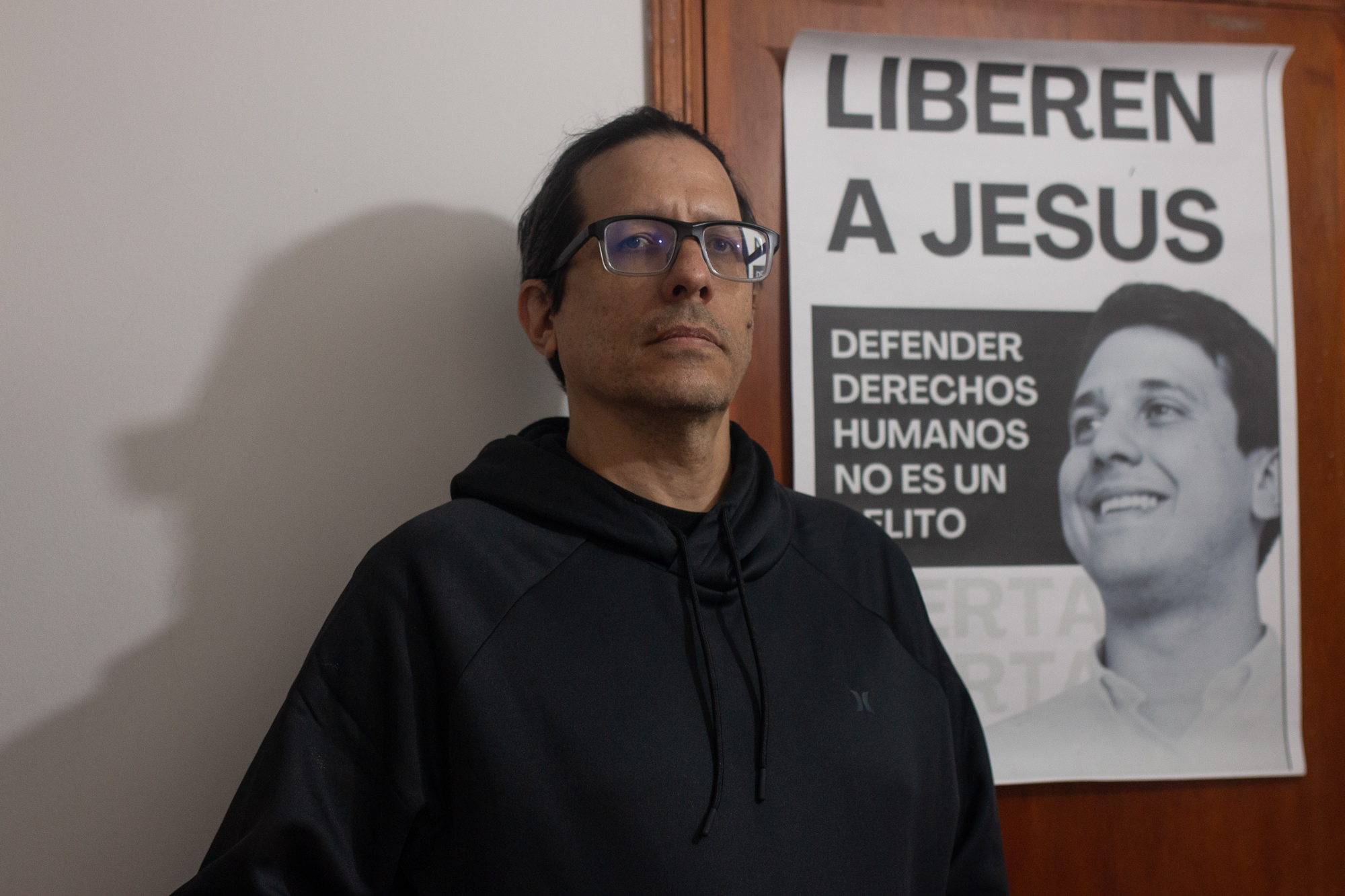 Jesus Rodriguez, in front of a poster that calls for the release of his relative, Jesus Armas