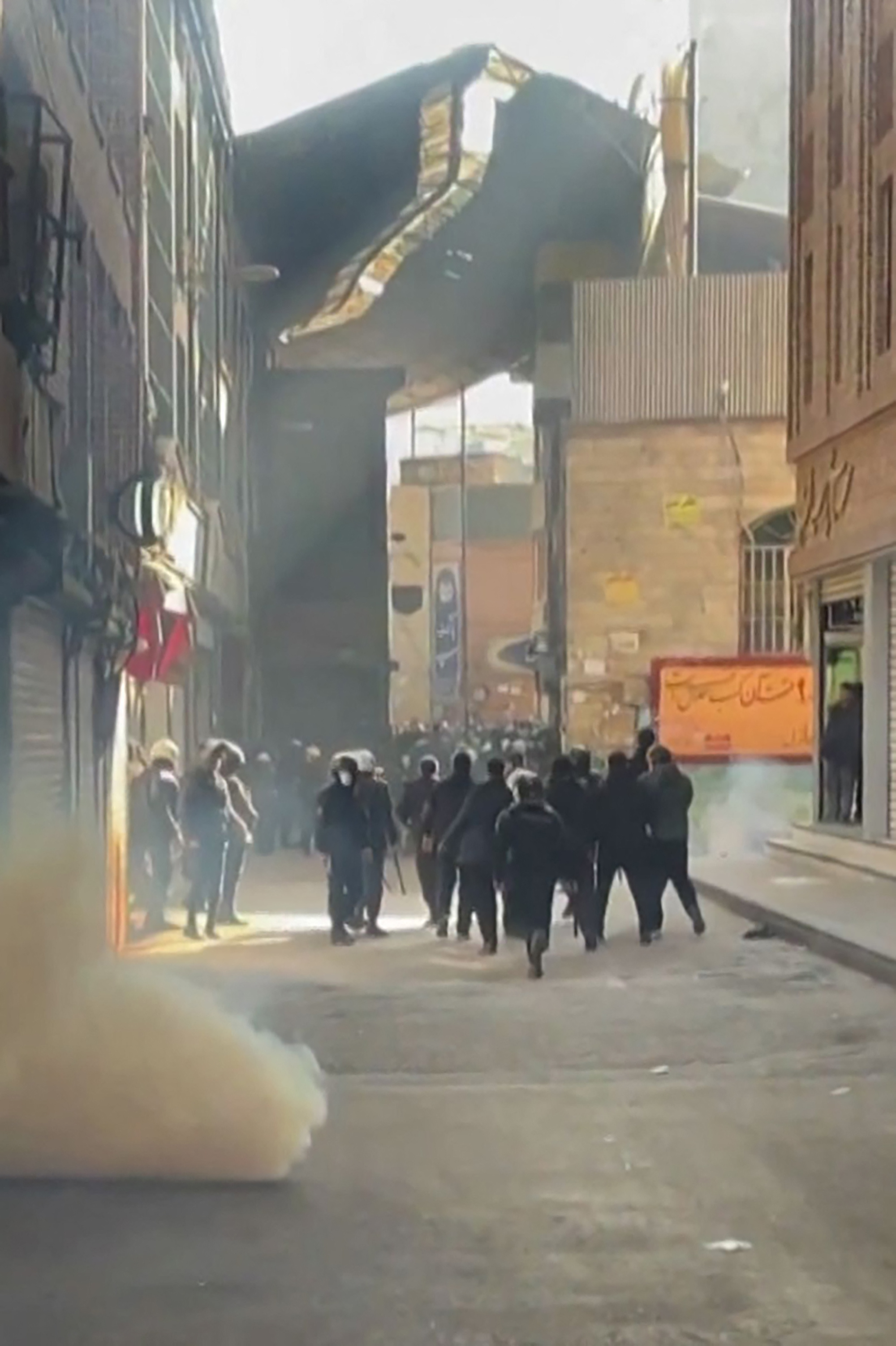 Iranian security forces using tear gas to disperse protesters at the Tehran bazaar.
