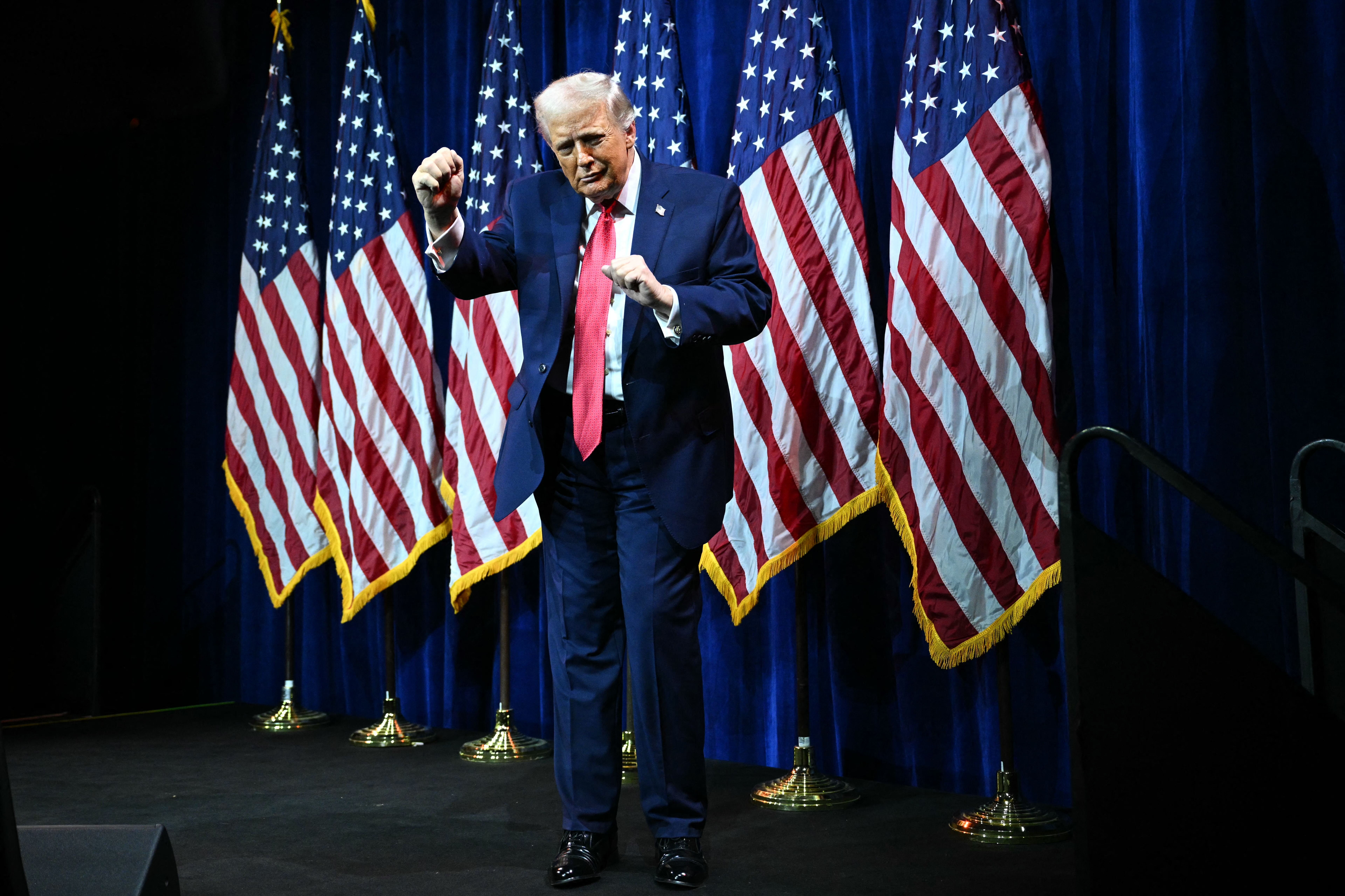TOPSHOT - US President Donald Trump does a little dance after he delivered remarks at the House Republican Party (GOP) member retreat at the Kennedy Center in Washington, DC, on January 6, 2026. (Photo by Mandel NGAN / AFP)
