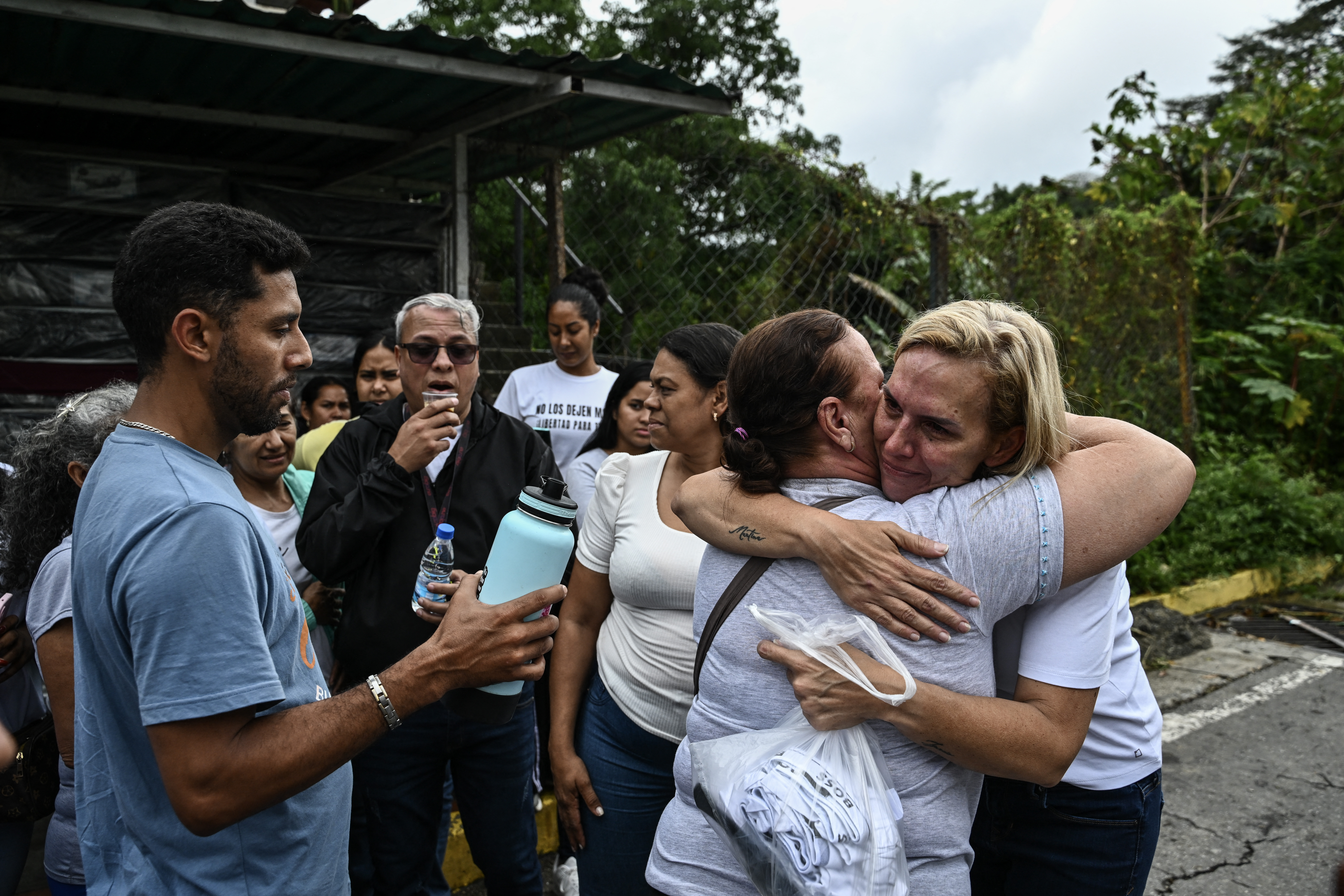 Mariana Gonzalez (R), daughter of exiled Venezuelan opposition figure Edmundo Gonzalez, hugs a woman after visiting her husband at El Rodeo I prison in Guatire, Miranda State, about 30 kilometers east of Caracas, on January 16, 2026.