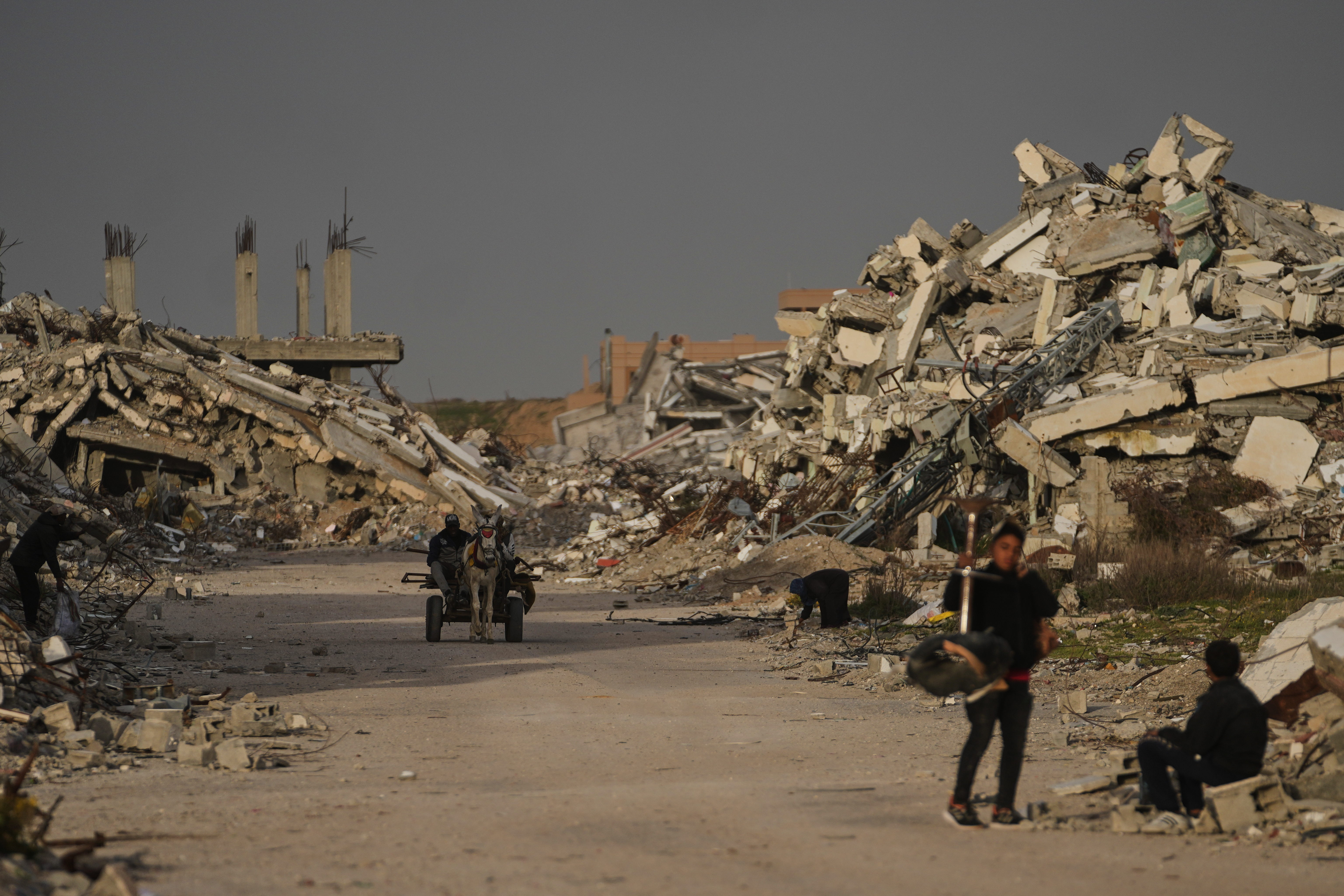Palestinians walks amid the ruins left by the Israeli air and ground offensive in Zahra, central Gaza Strip, Wednesday, Jan. 28, 2026. (AP Photo/Abdel Kareem Hana)