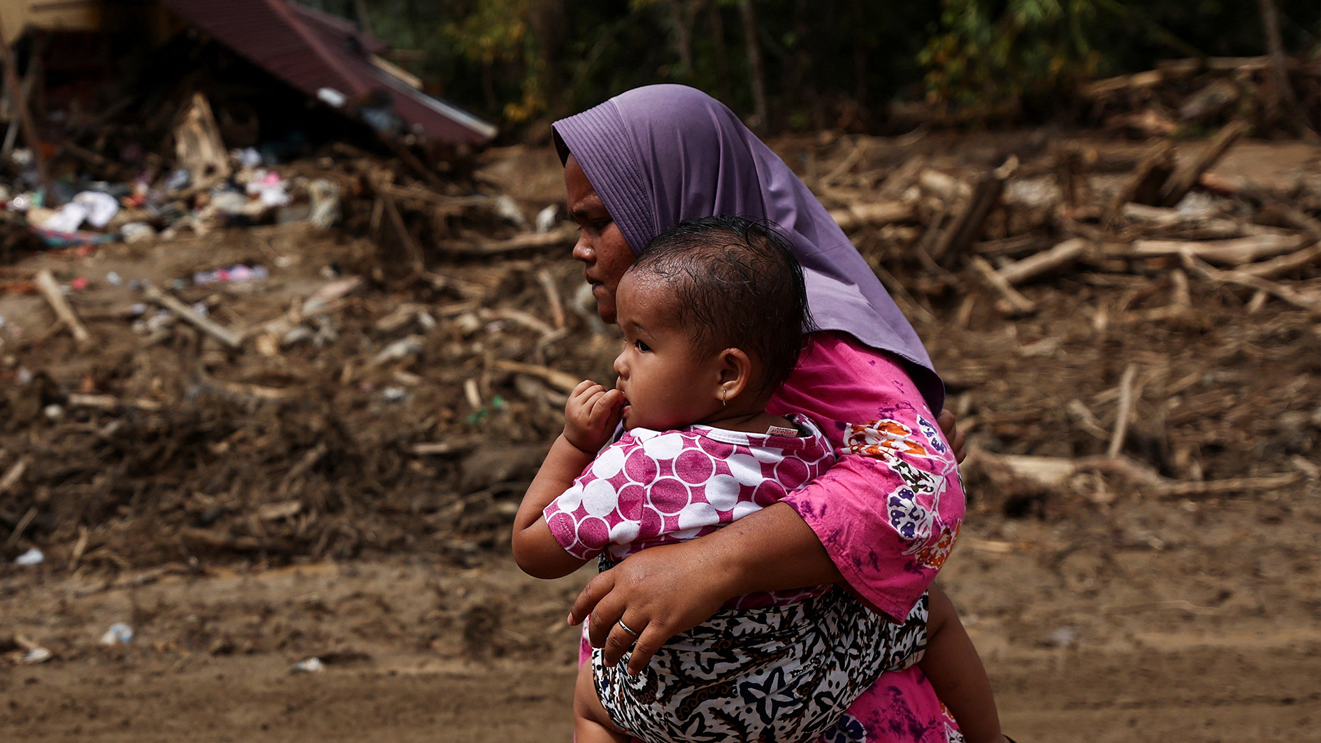 Woman and baby fleeing flood damage in Indonesia.