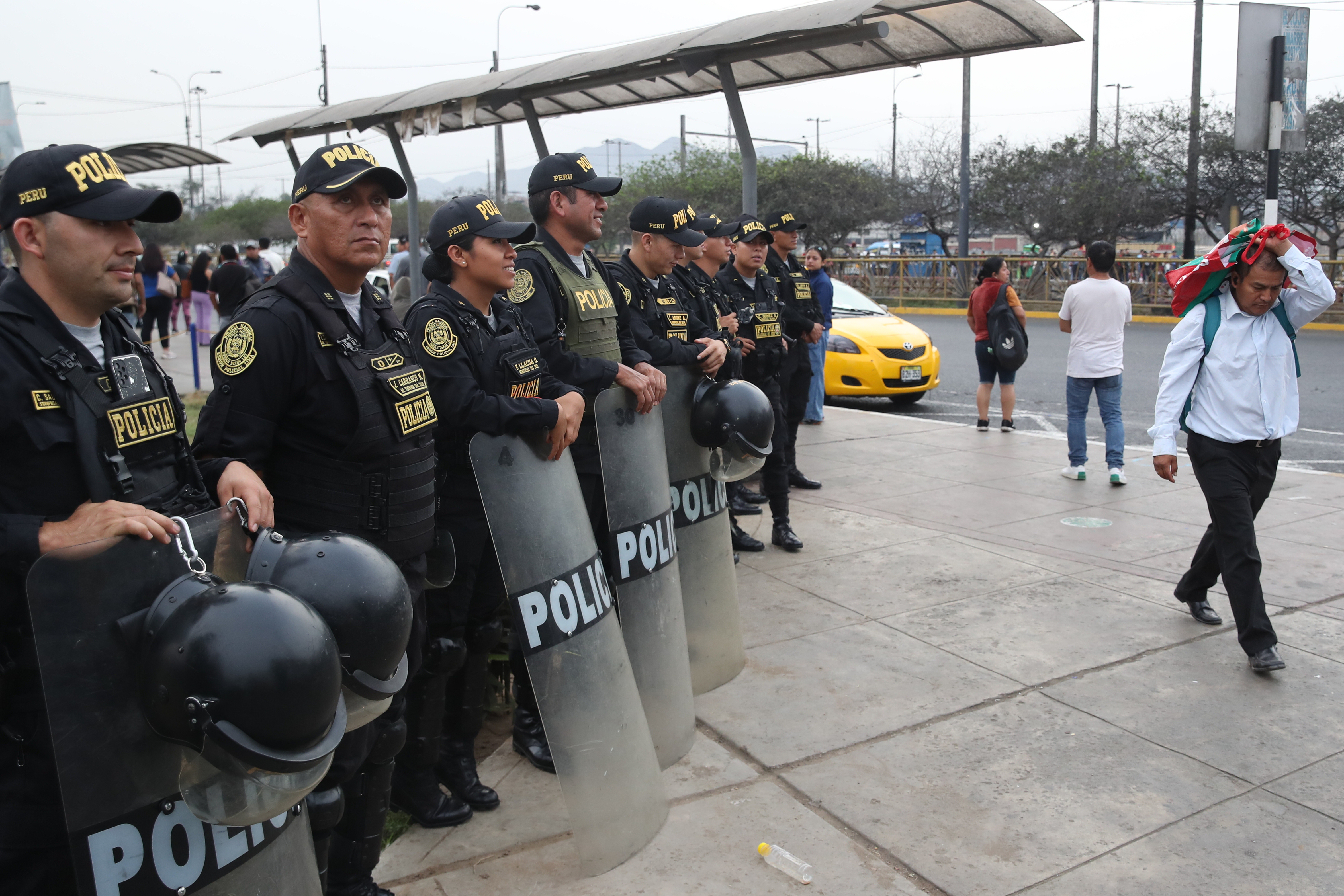 epa12648709 Members of the Peruvian Police guard a street in Lima, Peru, 14 January 2026. Urban transport unions in Lima are protesting against the government over the increase in extortion and murders of their workers by organized crime. EPA/Paolo Aguilar