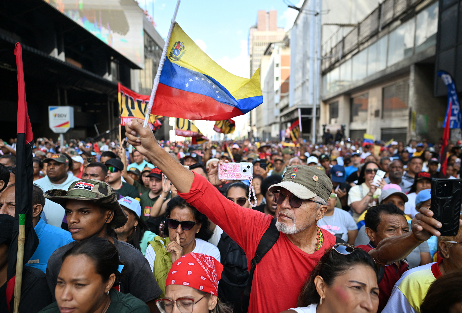 A supporter of ousted Venezuela's President Nicolas Maduro waves a Venezuelan flag during a rally to watch a session of the National Assembly on a big screen in Caracas on Jan. 5, 2026. Venezuela's new parliament opened on January 5 with lawmakers chanting "Let's go Nico!" as they forcibly denounced the recent capture of leftist leader Nicolas Maduro in a US military operation on Jan. 3. [Juan Barreto/AFP]