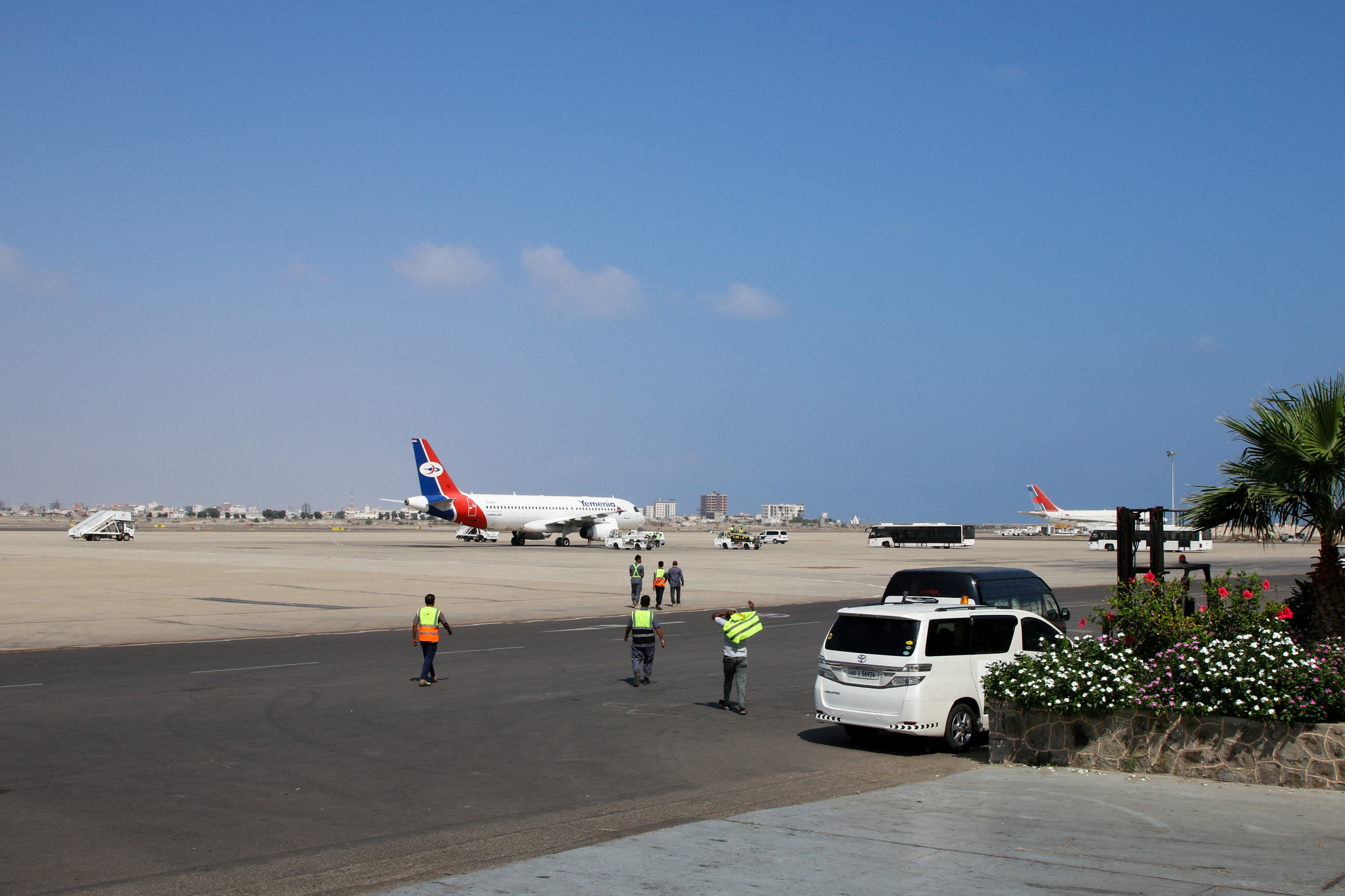 Airport staff walk towards a Yemen Airways (Yemenia) plane after it landed at Aden Airport in Aden, Yemen January 1, 2026. REUTERS/Fawaz Salman