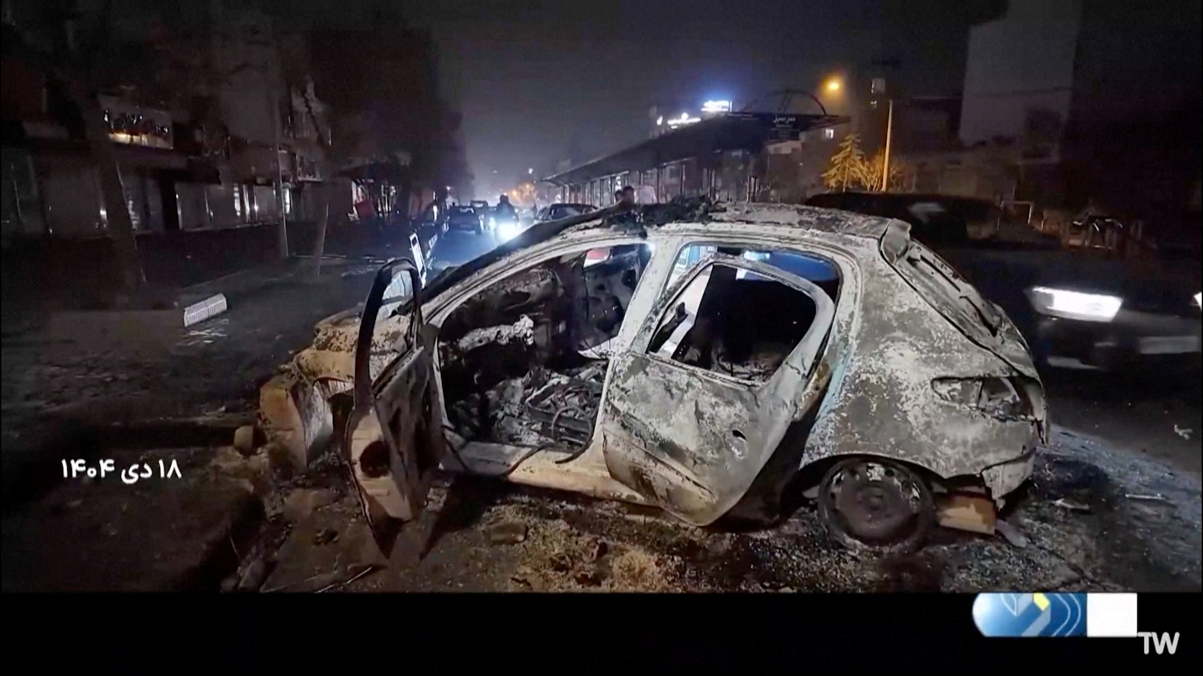 A burnt car lies on the road following unrest sparked by dire economic conditions, in a place given as Tehran, Iran, January 10, 2026, in this screengrab from Iran's state media broadcast footage. IRIB via WANA(West Asia News Agency) via REUTERS ATTENTION EDITORS - THIS PICTURE WAS PROVIDED BY A THIRD PARTY. IRAN OUT. NO COMMERCIAL OR EDITORIAL SALES IN IRAN NO USE BBC PERSIAN. NO USE VOA PERSIAN. NO USE MANOTO. NO USE IRAN INTERNATIONAL. NO USE RADIO FARDA. FOR REUTERS CUSTOMERS ONLY. TEXT OVERLAY FROM SOURCE.