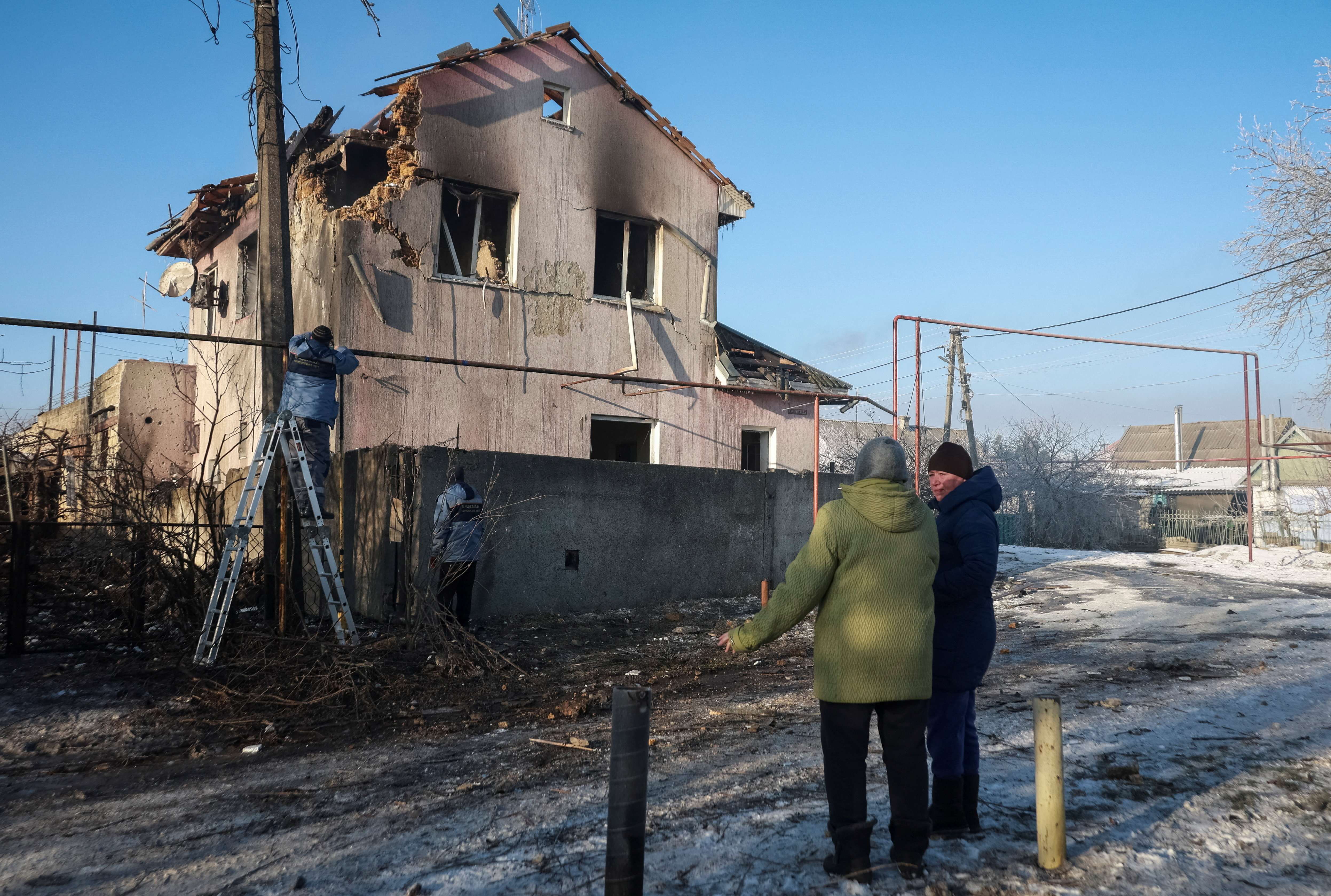 Residents stand at the site of the Russian drone strike, amid Russia's attack on Ukraine, near the city of Chornomorsk, Odesa region, Ukraine January 21, 2026. REUTERS/Nina Liashonok