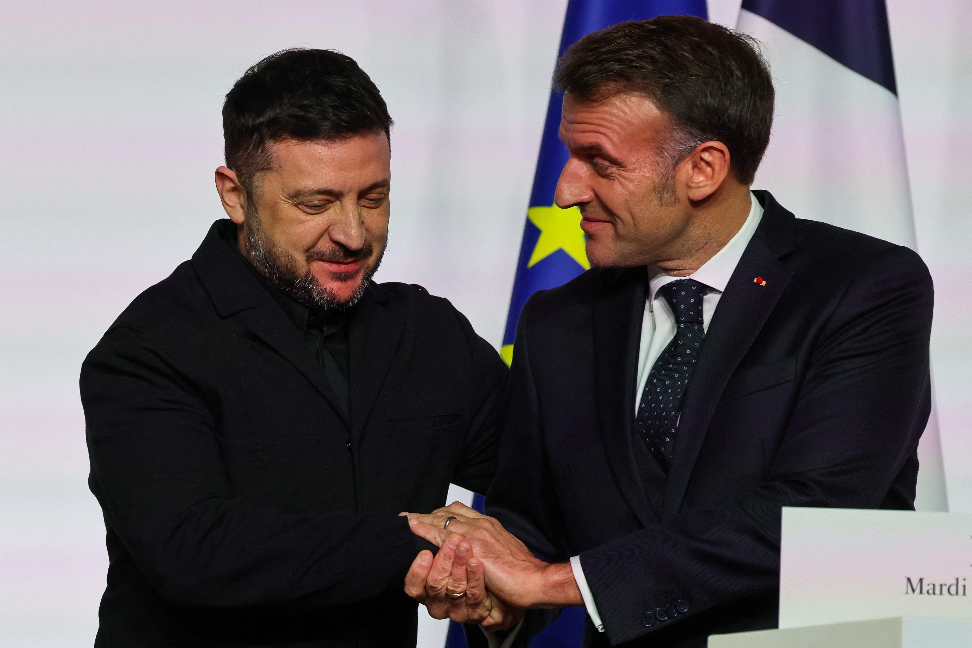 France's President Emmanuel Macron and Ukraine's President Volodymyr Zelenskiy shake hands as they deliver a press conference upon the signing of the declaration on deploying post-ceasefire force in Ukraine during the so-called 'Coalition of the Willing' summit, at the Elysee Palace in Paris, France, January 6, 2026. Ludovic Marin/Pool via REUTERS