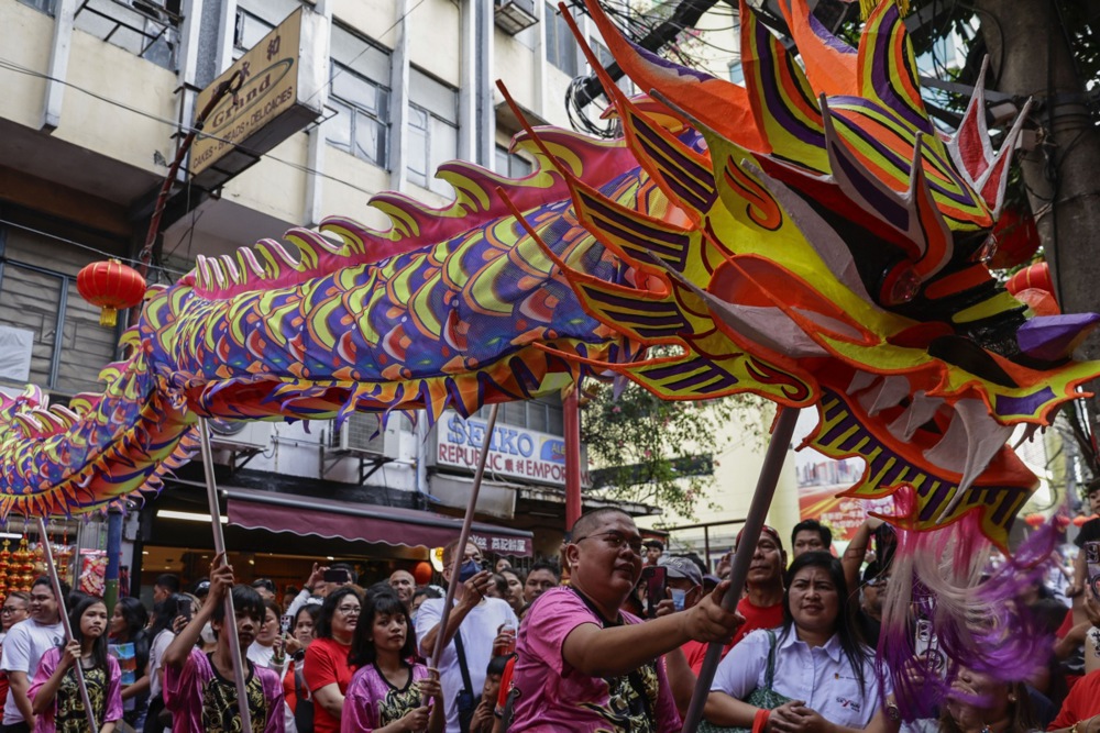 Dragon dance performers entertain a crowd celebrating Chinese Lunar New Year.