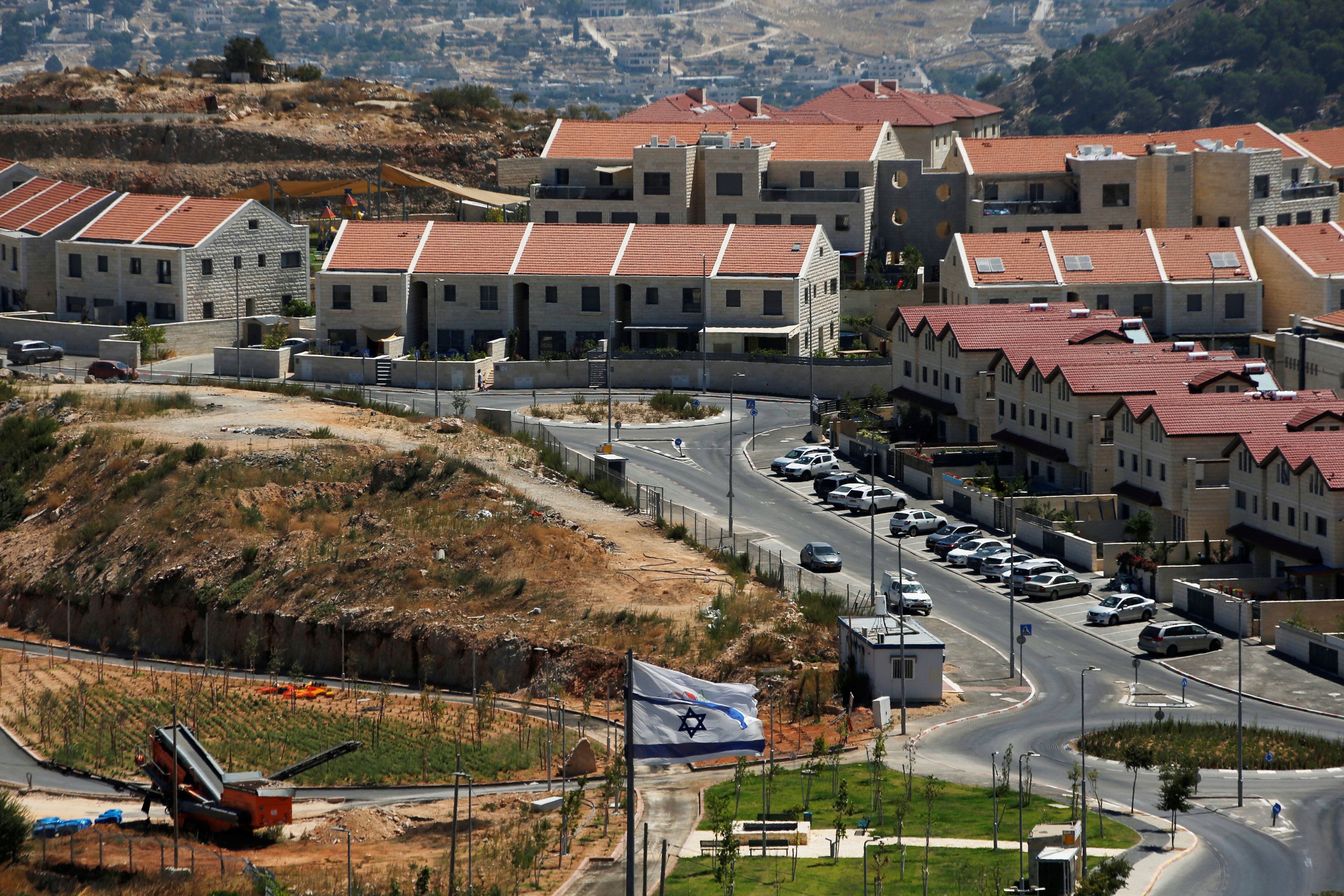 The Israeli national flag flutters as apartments are seen in the background in the Israeli settlement of Efrat in the Israeli-occupied West Bank August 18, 2020. Picture taken August 18, 2020. REUTERS/Ronen Zvulun