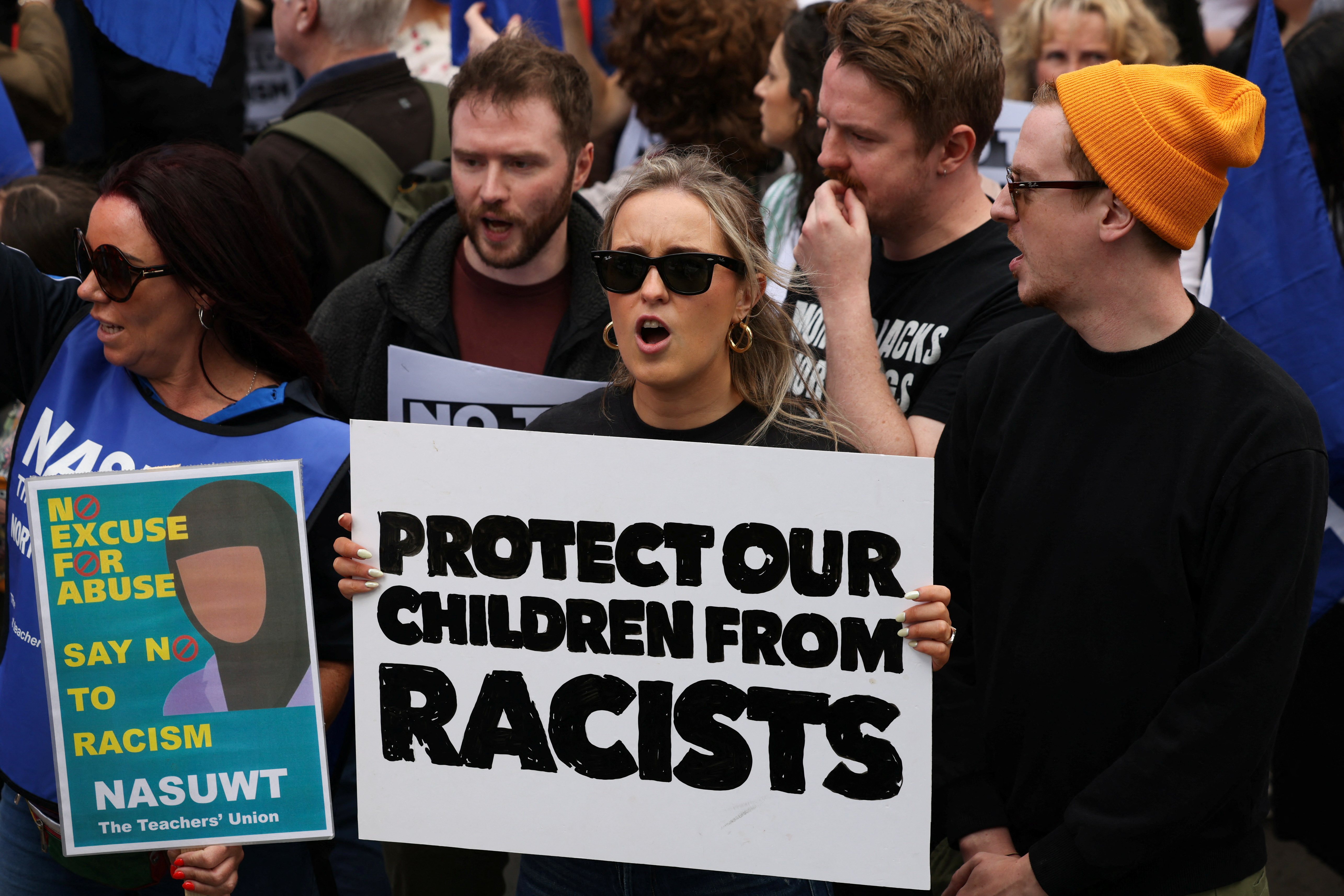 Protesters hold placards during an antiracism protest.