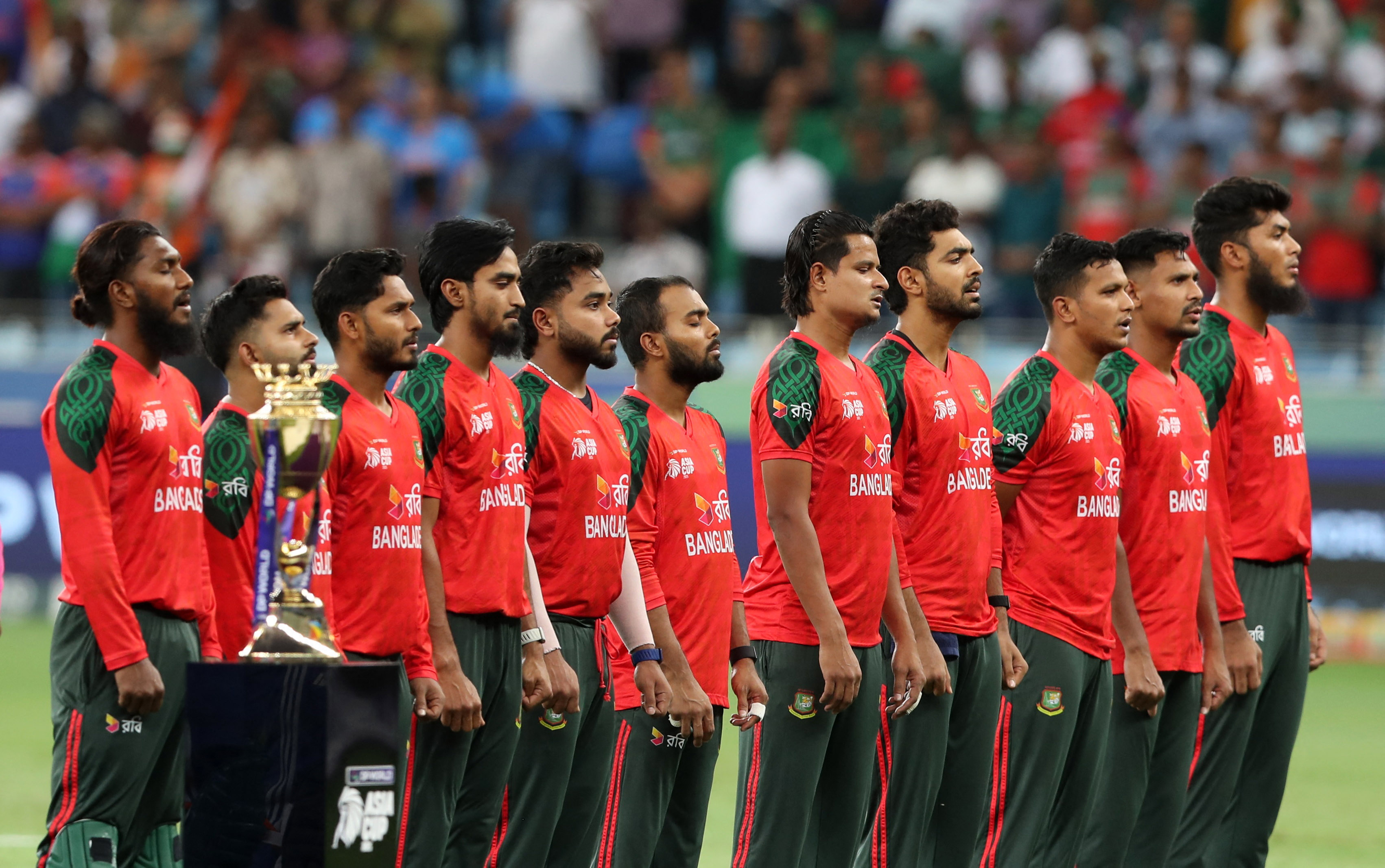 Cricket - Asia Cup - India v Bangladesh - Dubai International Cricket Stadium, Dubai, United Arab Emirates - September 24, 2025 General view of the trophy as the Bangladesh players line up during the national anthems before the match REUTERS/Satish Kumar
