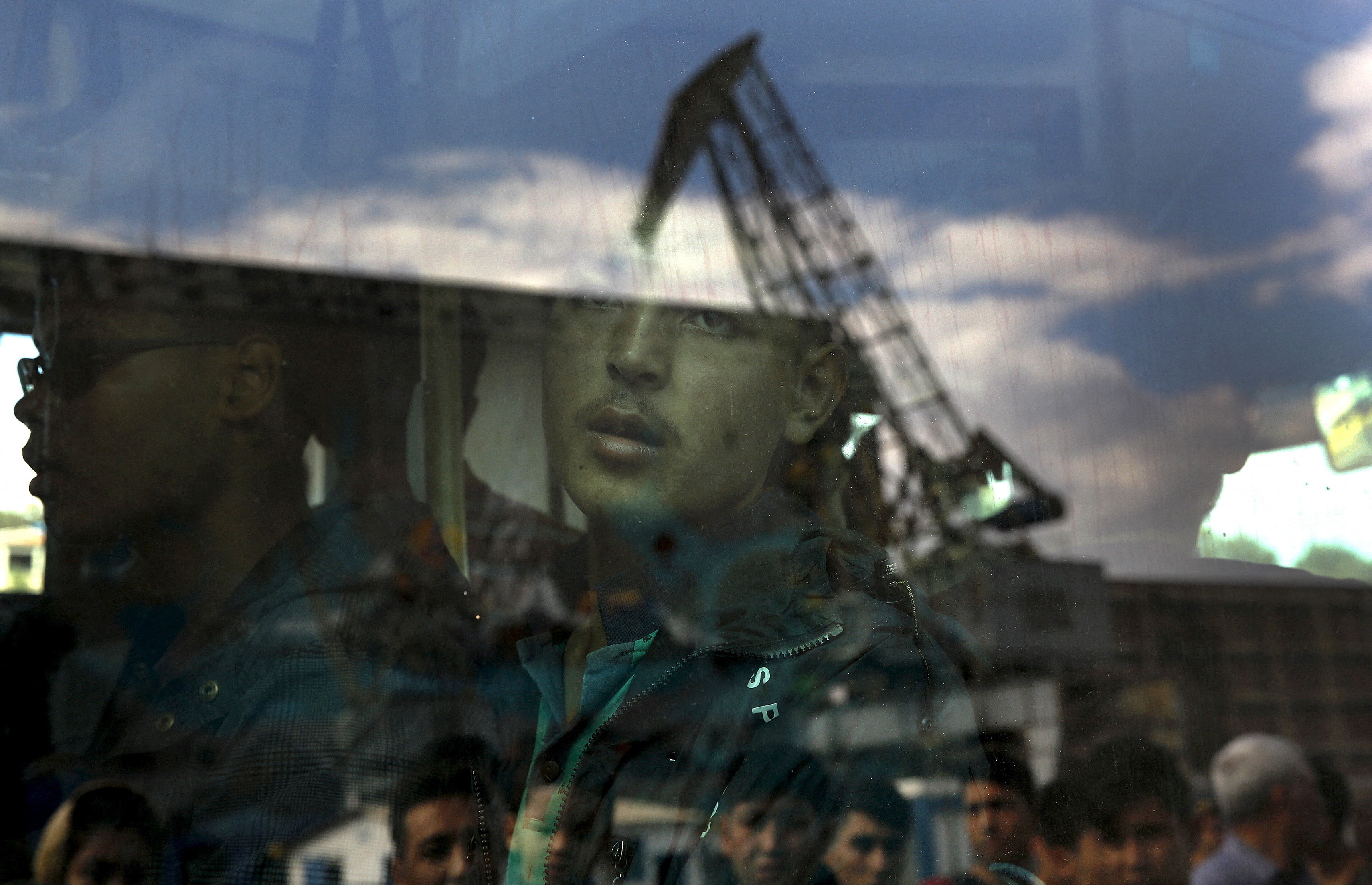 REUTERS PICTURES 40th ANNIVERSARY COLLECTION: An Afghan migrant is seen inside a bus following his arrival by the Eleftherios Venizelos passenger ferry with over 2,500 migrants and refugees from the island of Lesbos at the port of Piraeus, near Athens, Greece, October 8, 2015. Refugee and migrant arrivals to Greece this year will soon reach 400,000, according to the UN Refugee Agency (UNHCR) REUTERS/Yannis Behrakis SEARCH "REUTERS PICTURES 40th ANNIVERSARY COLLECTION" FOR THIS PACKAGE