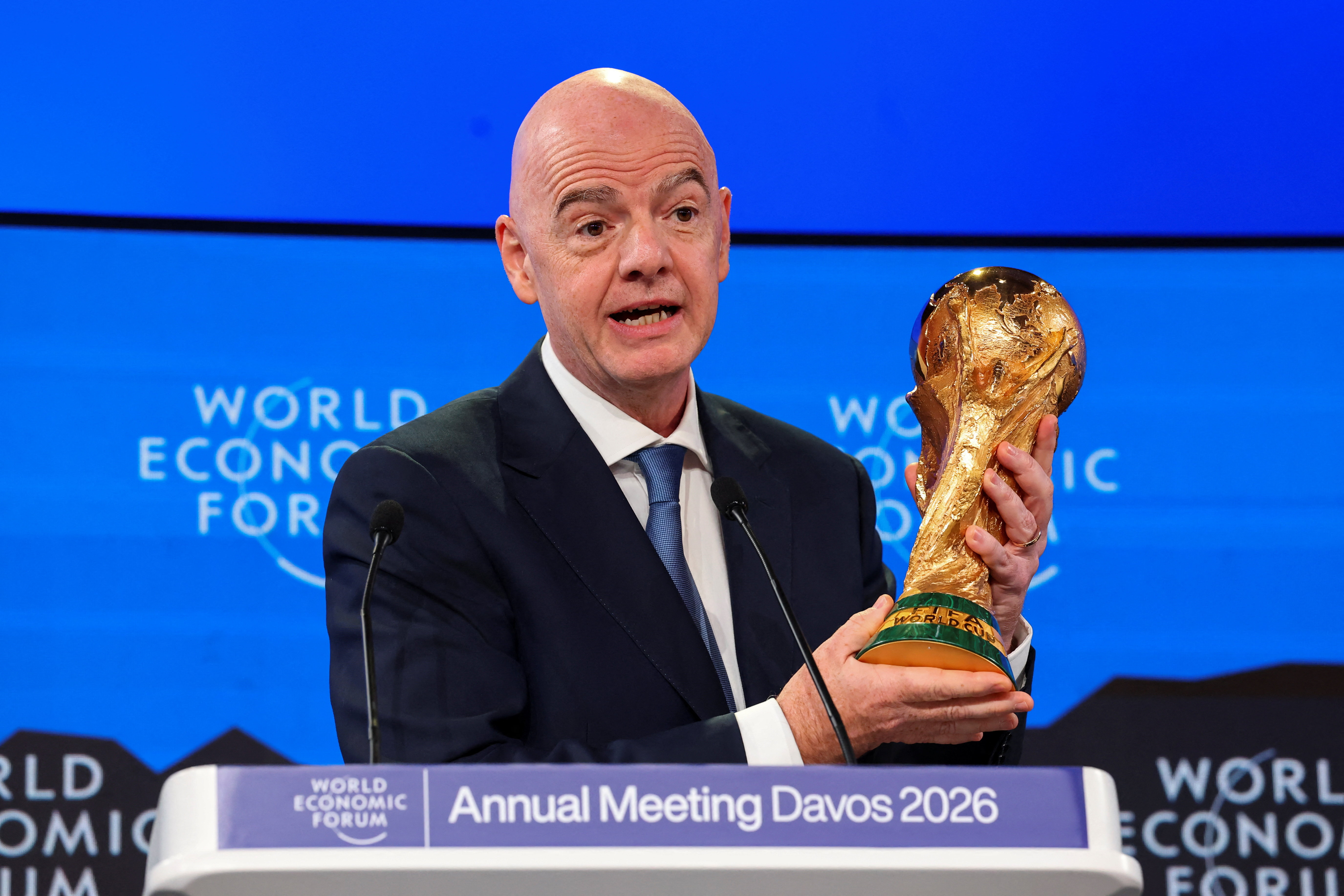 FIFA President Gianni Infantino holds the FIFA World Cup trophy as he attends the 56th annual World Economic Forum (WEF) meeting in Davos, Switzerland, January 22, 2026. REUTERS/Denis Balibouse