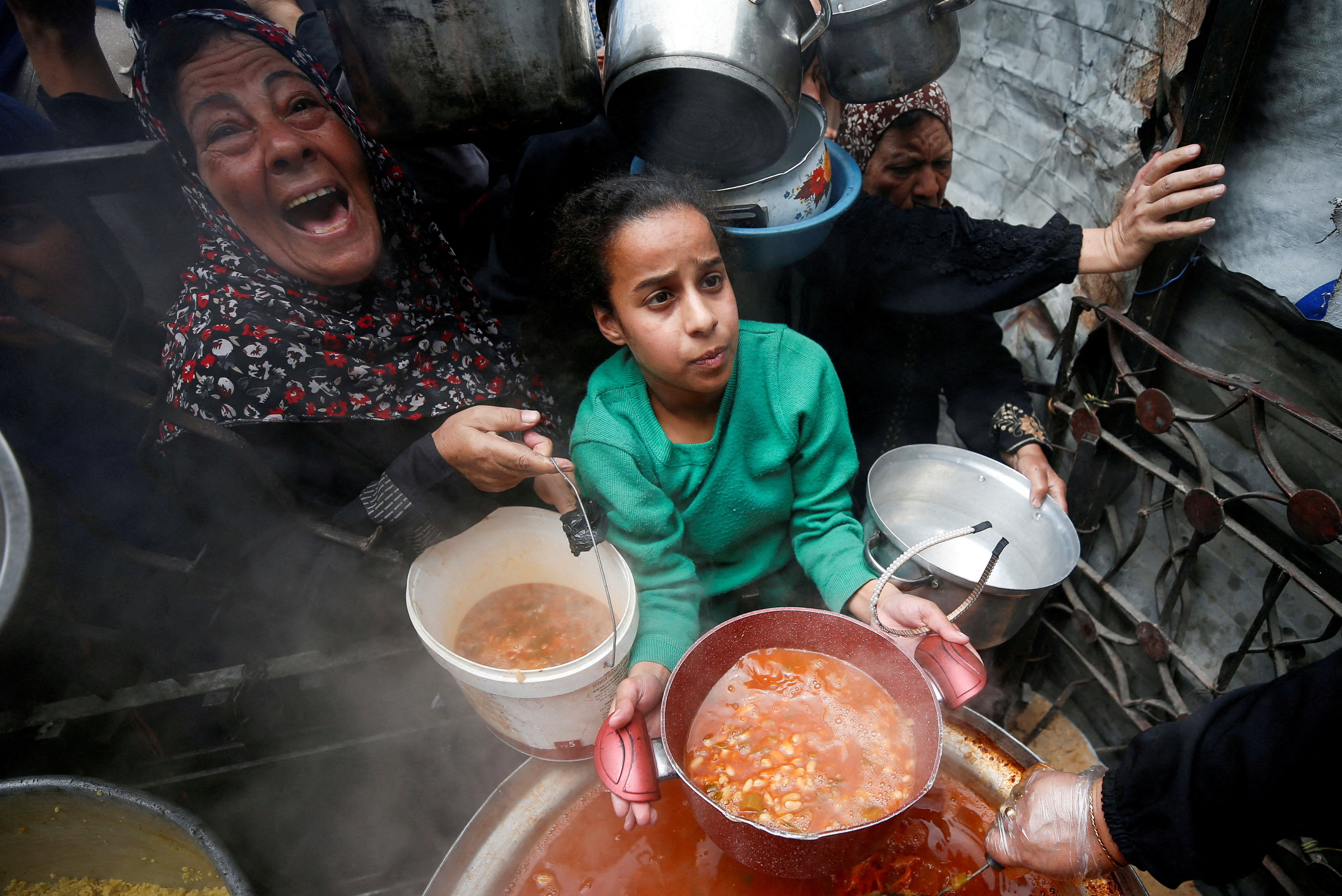 Palestinians receive food cooked by a charity kitchen, in Beit Lahiya, northern Gaza Strip, April 28, 2025. REUTERS/Mahmoud Issa TPX IMAGES OF THE DAY