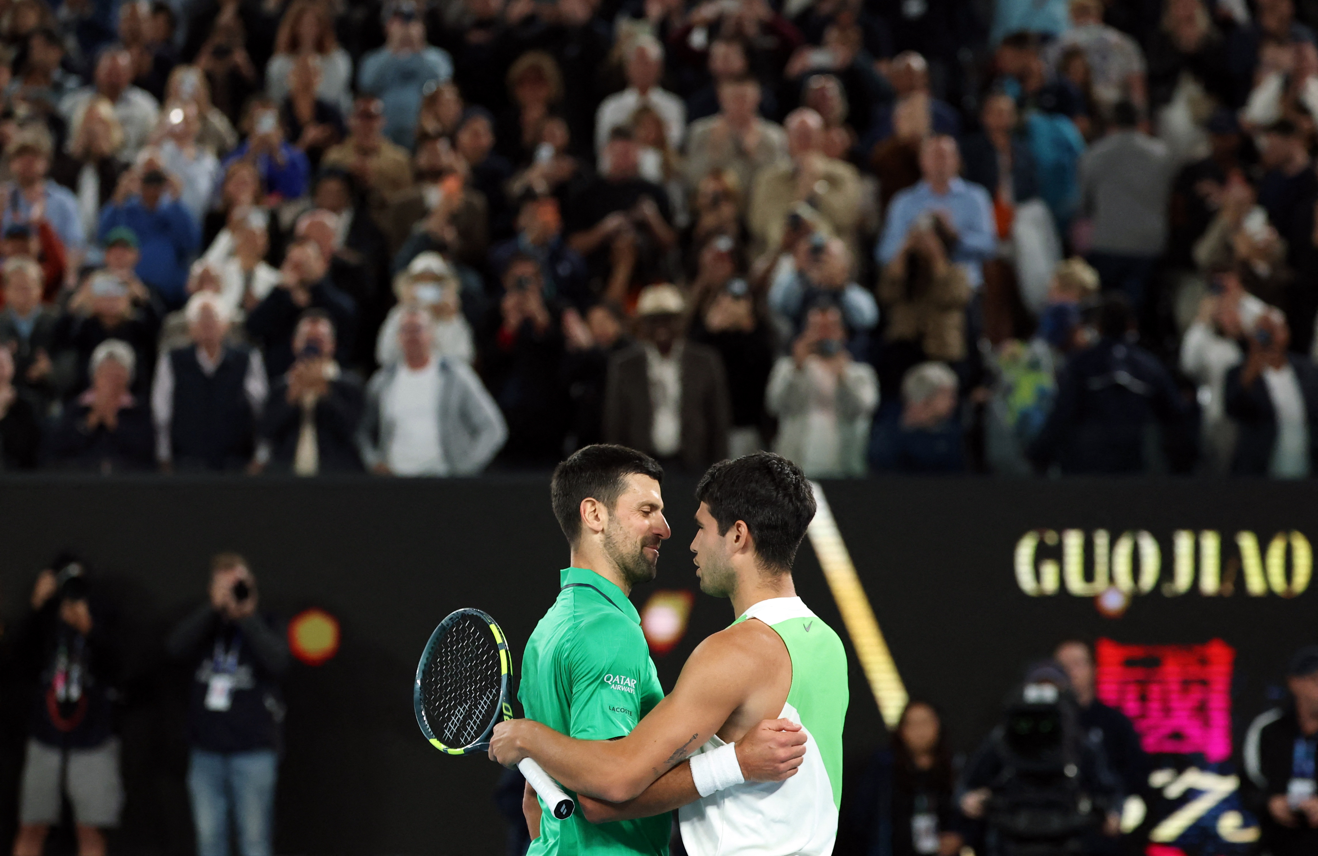 Tennis - Australian Open - Melbourne Park, Melbourne, Australia - February 1, 2026 Spain's Carlos Alcaraz with Serbia's Novak Djokovic after winning the Australian Open men's singles. Alcaraz becomes the youngest man to win all four grand slam titles. REUTERS/Edgar Su