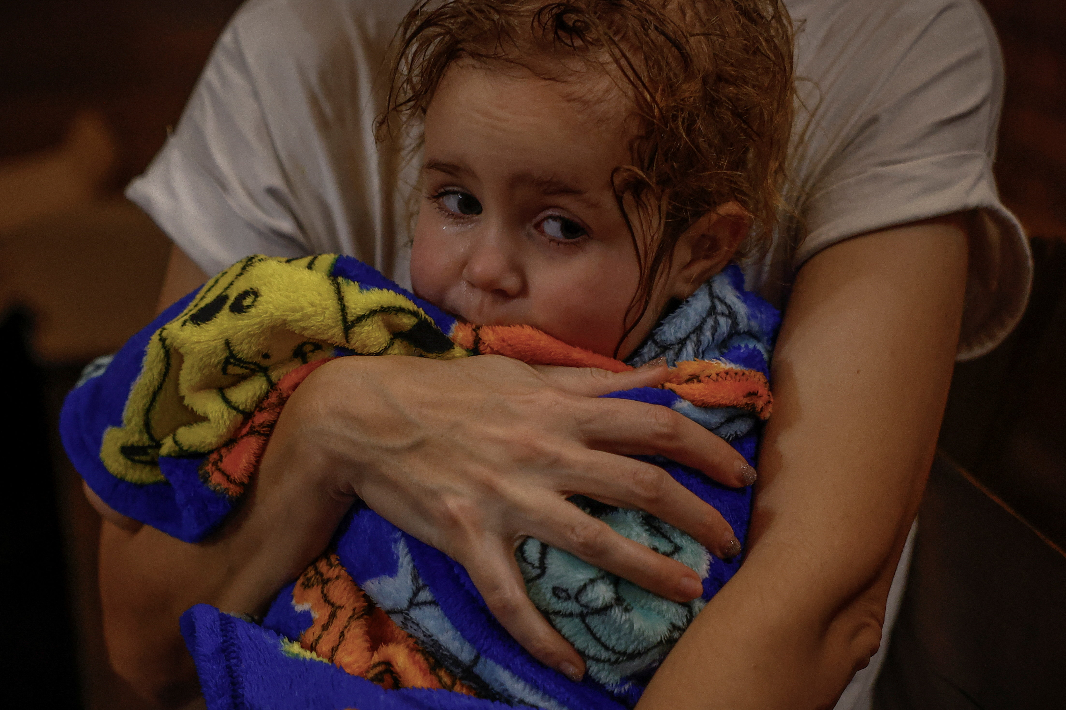 Yuliia Davydenko, 40, holds her daughter Stephanie, 2, wrapped in a towel after showering at a public bathhouse, as their apartment has no heating or hot water and faces frequent power outages amid Russia's attack on Ukraine, in Kyiv, Ukraine, February 3, 2026. Waves of Russian attacks over the past four months left hundreds of thousands without electricity and water, making this the most devastating winter since the war started; and so the Davydenko family made the choice to stay at the family-owned Piggy Cafe Kyiv - with power supplied by a generator and heating. "The point when we decide to leave Kyiv again would be when Russian troops are 10-12 km from the city. That's it," Yuliia Davydenko, 40, said. REUTERS/Alina Smutko SEARCH "SMUTKO COLD FAMILY" FOR THIS STORY. SEARCH "WIDER IMAGE" FOR ALL STORIES. TPX IMAGES OF THE DAY