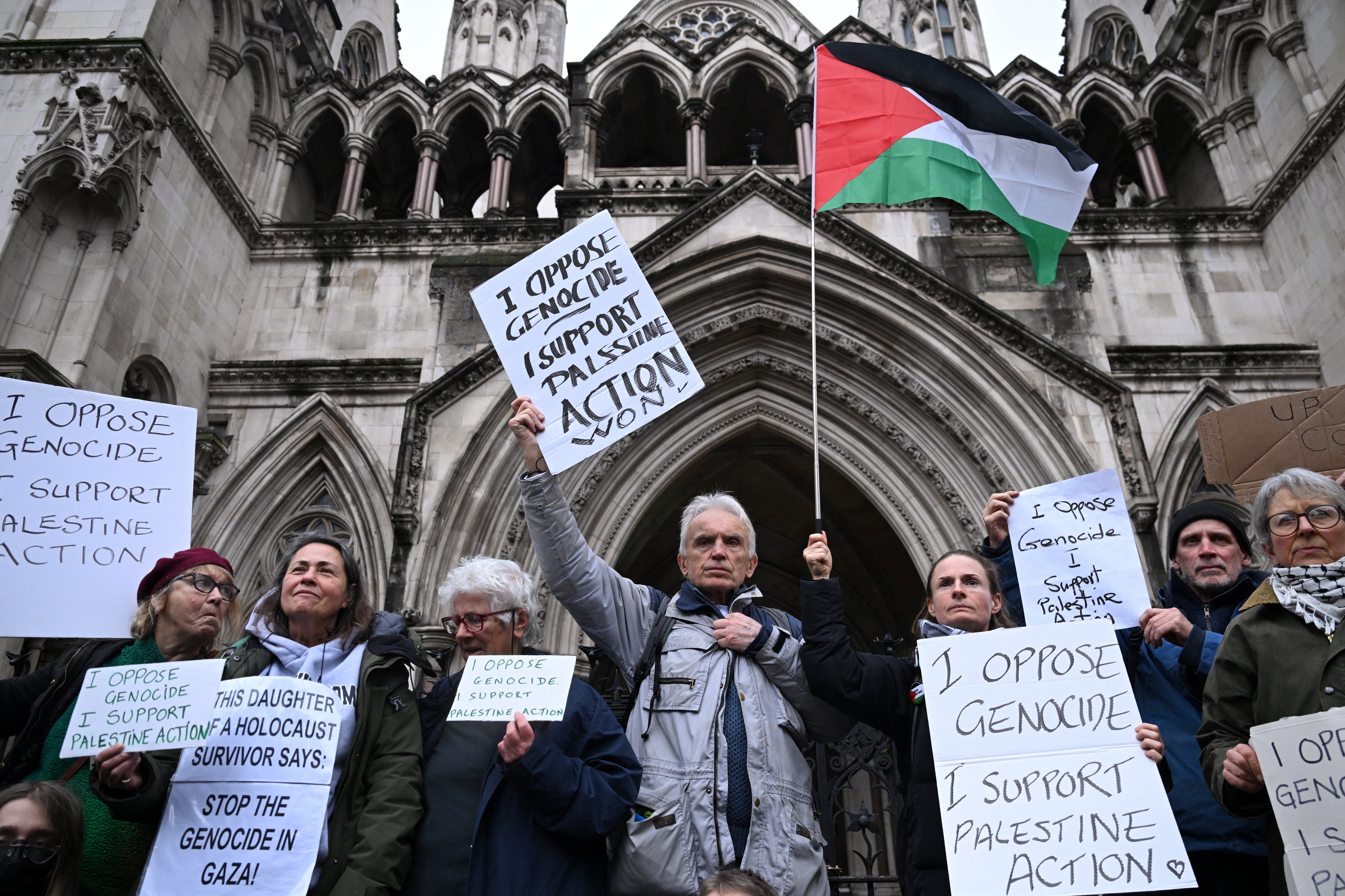 Protesters hold signs outside the Royal Courts of Justice, after High Court judges ruled the British government’s decision to designate pro‑Palestinian group Palestine Action as a terrorist organisation unlawful, in London, Britain, February 13, 2026. REUTERS/Jaimi Joy
